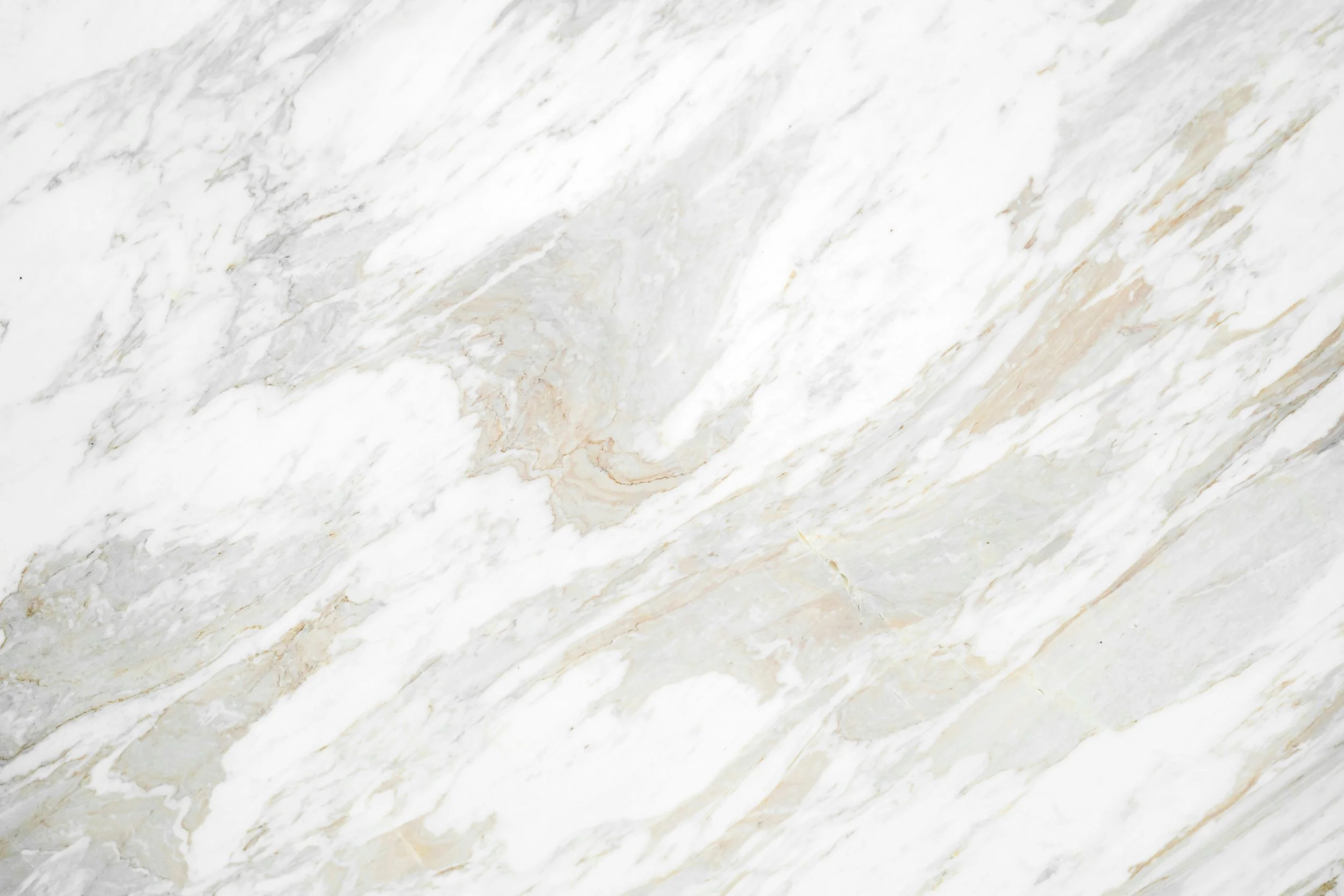 Close-up of a white marble surface with gray and beige veining.