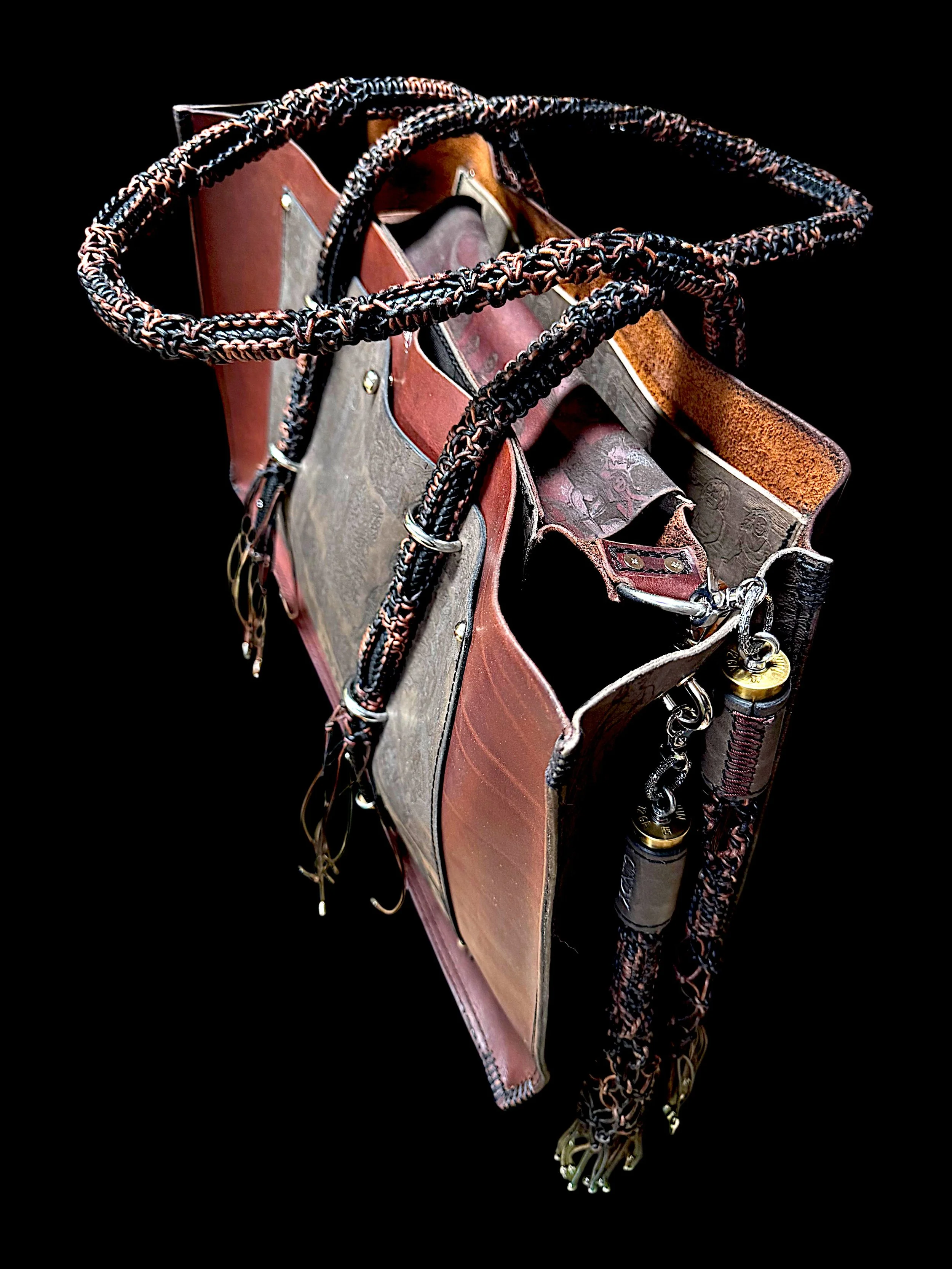 A leather riding crop with a braided handle, attached to a saddle with stirrups, on a black background.