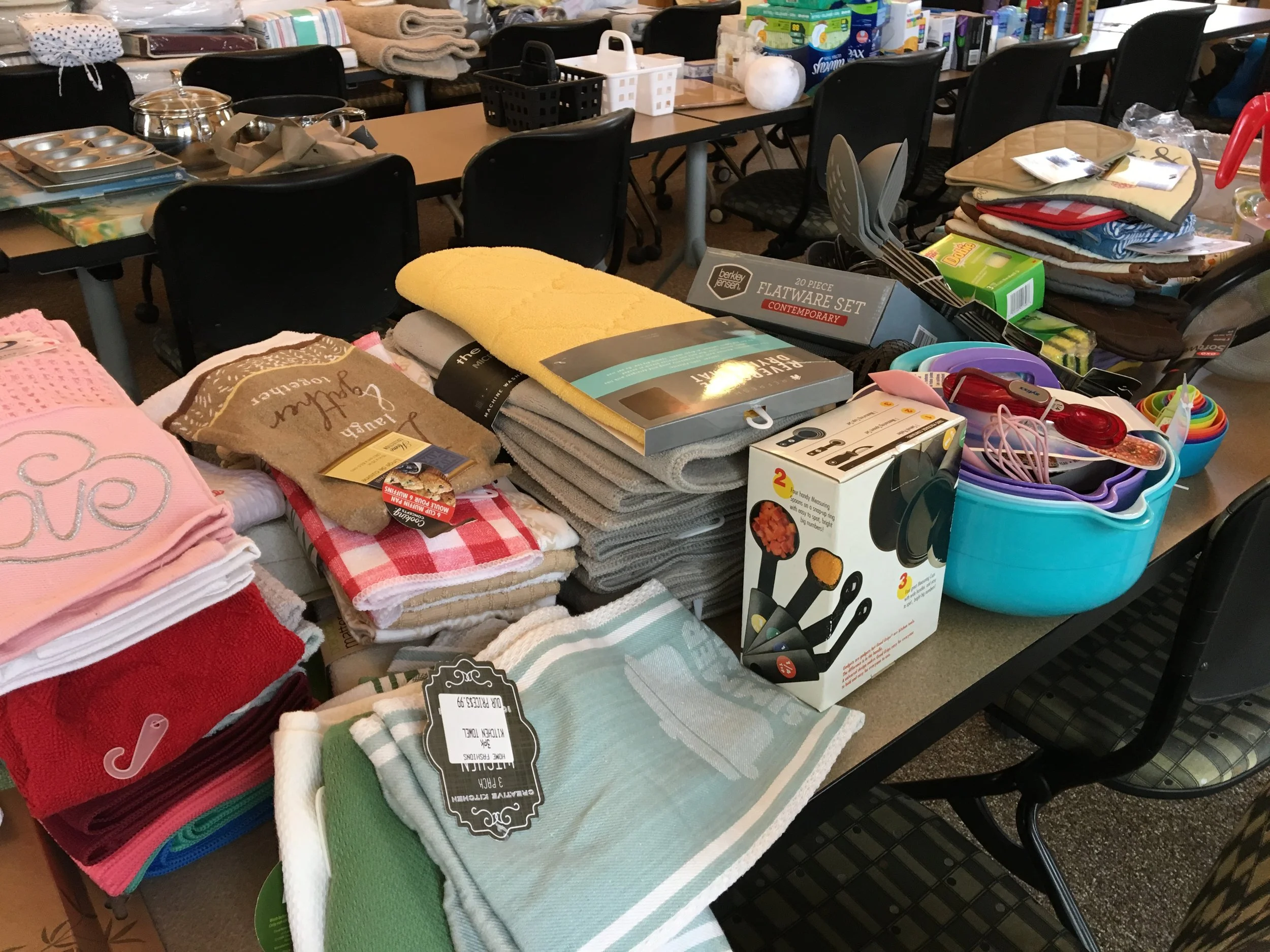 Clothing and household items for donation, including towels, blankets, kitchenware, and small appliances.