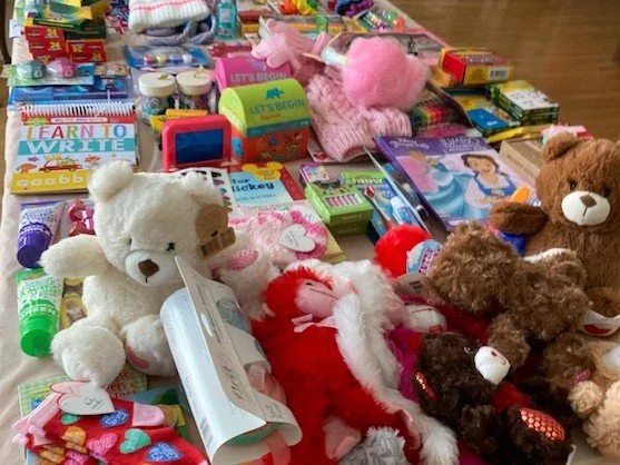 A collection of toys, teddy bears, and children's books on a table