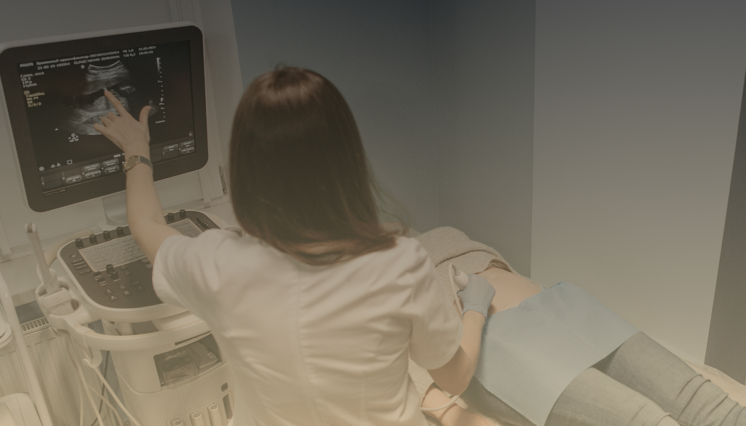 Medical professional performing an ultrasound on a patient lying on a hospital bed.