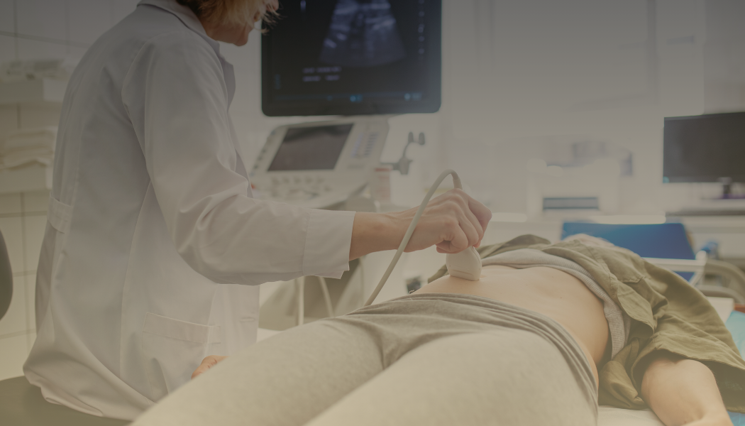 Medical professional performing an ultrasound on a patient lying on a hospital bed.