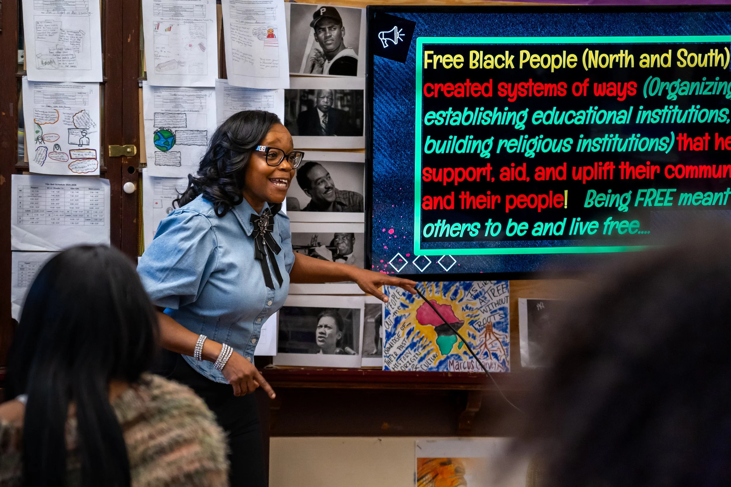 Boston Public Schools educator Tanisha Milton points at the teaching screen in her AP African American Studies classroom at TechBoston Academy in Dorchester, Massachusetts.