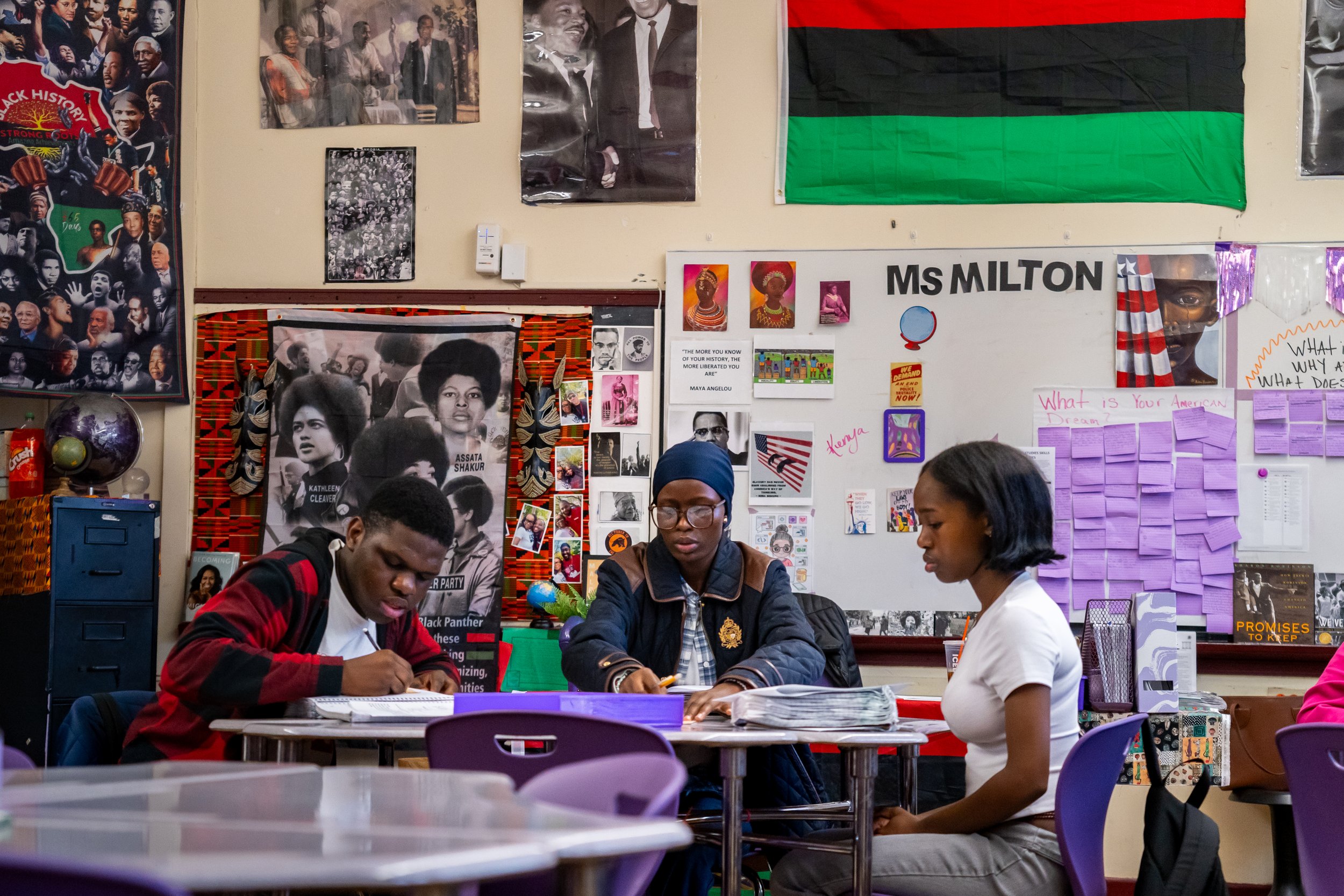 A group of Boston Public Schools students participate in a class activity at a table in Boston Public Schools educator Tanisha Milton's AP African American Studies class.