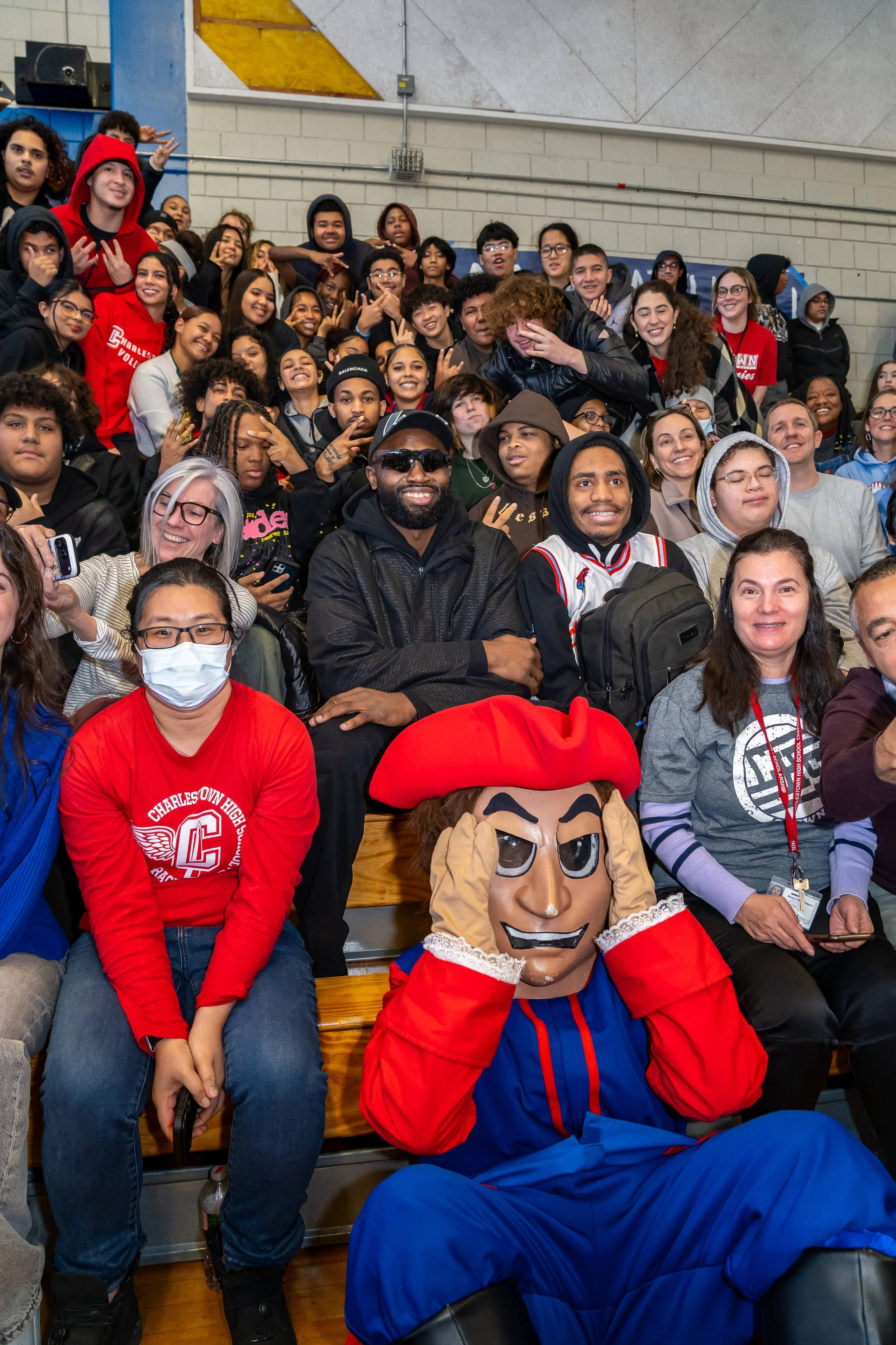 NBA Star and former Boston Celtics and current Philadelphia 76ers basketball player Jaylen Brown and streamer DDG pose with a group of Charlestown High School students.