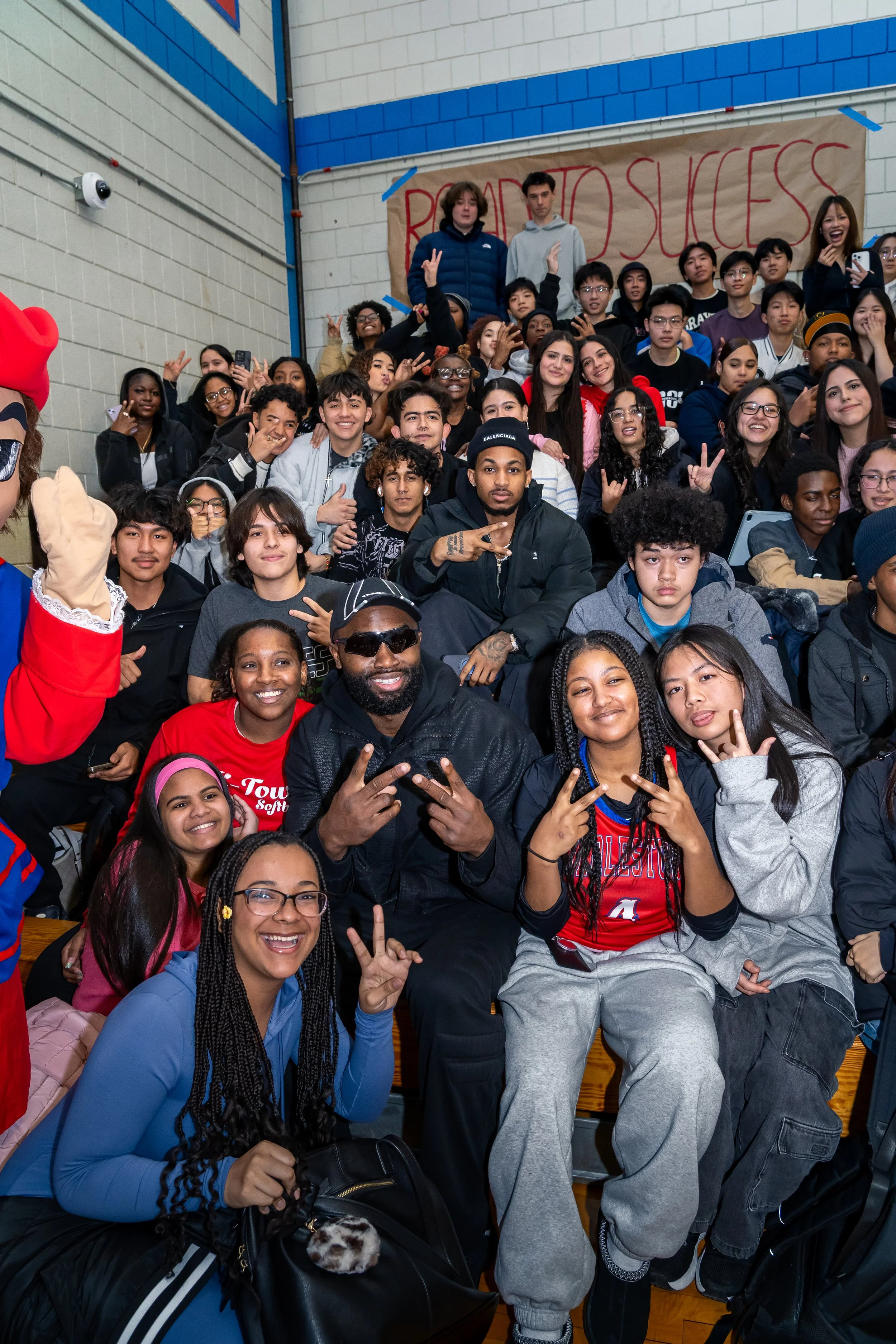 NBA Star and former Boston Celtics and current Philadelphia 76ers basketball player Jaylen Brown and streamer DDG pose with a group of Charlestown High School students.