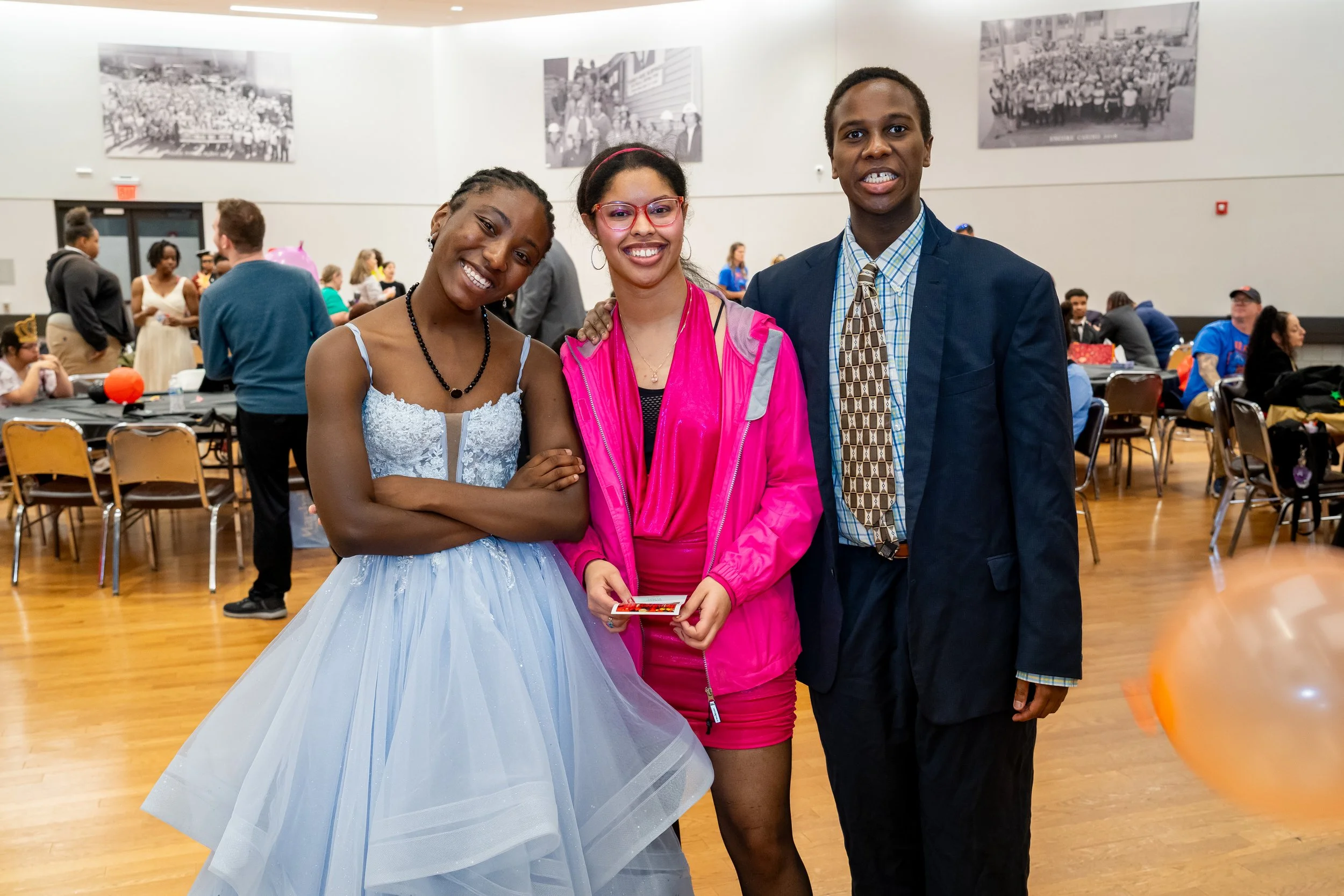 Three Boston Public Schools students in formal attire pose for a photo.
