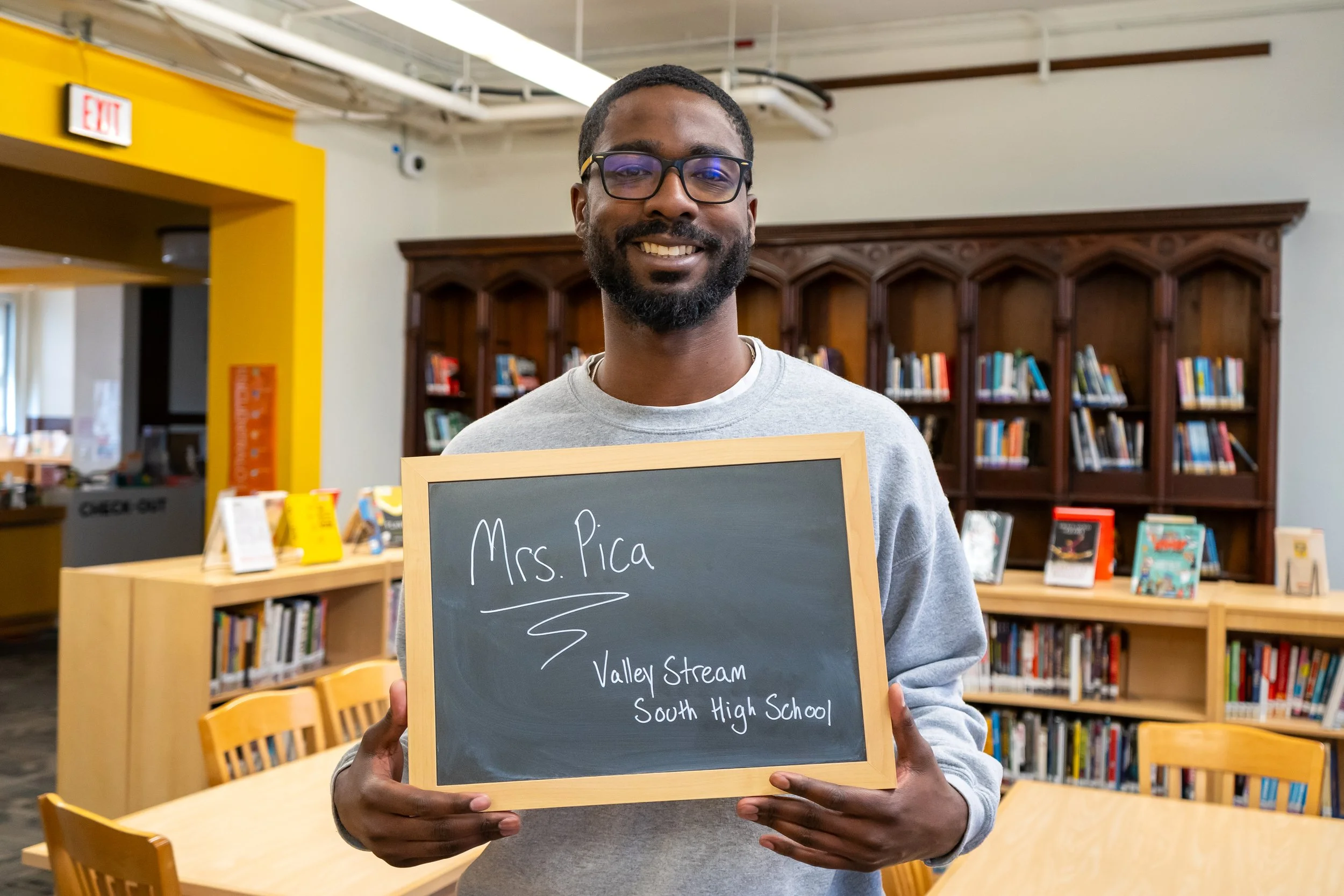 Boston educator poses with a chalkboard.