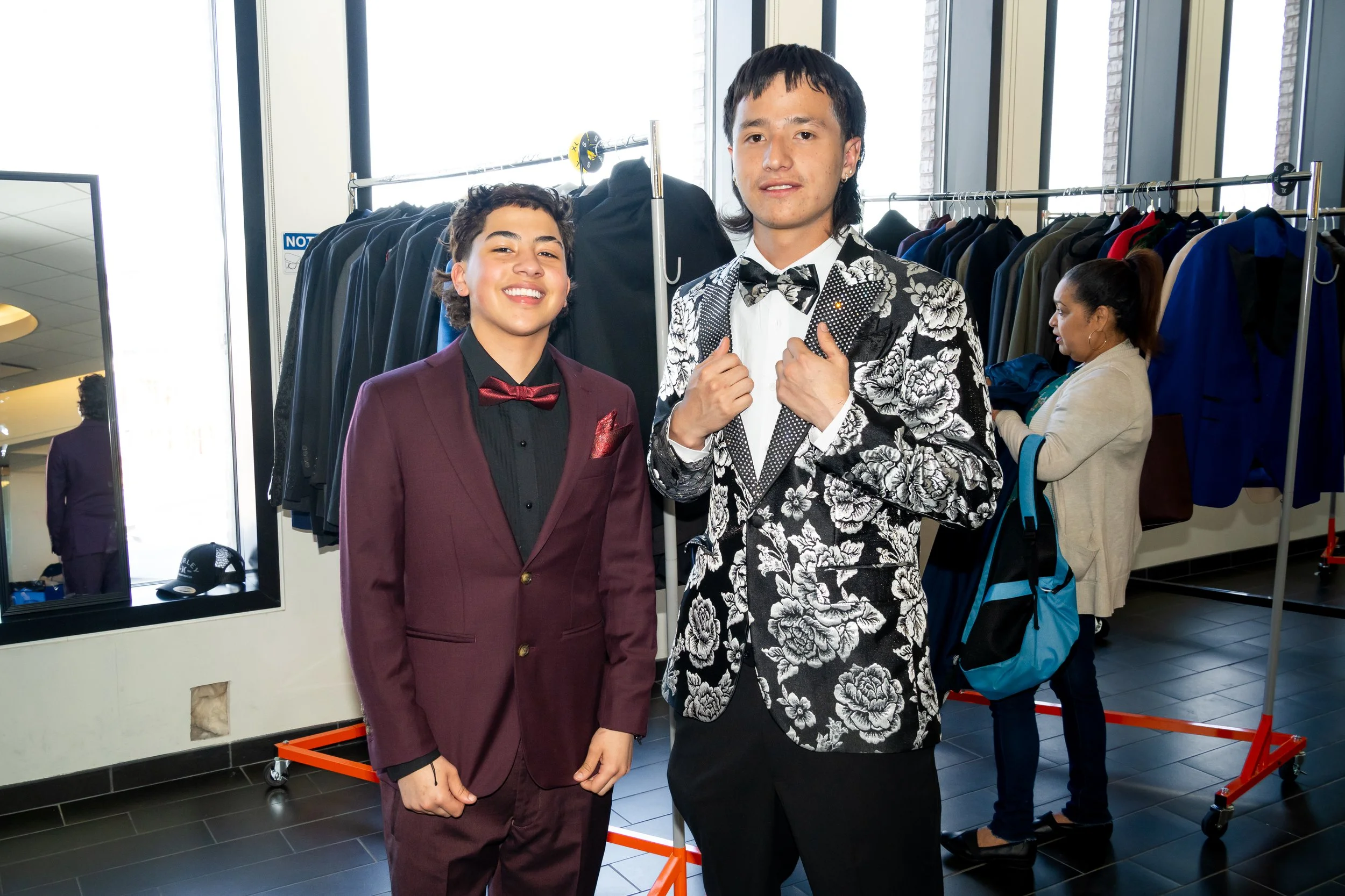 Two Boston Public Schools students pose for a photo with suit jackets. 