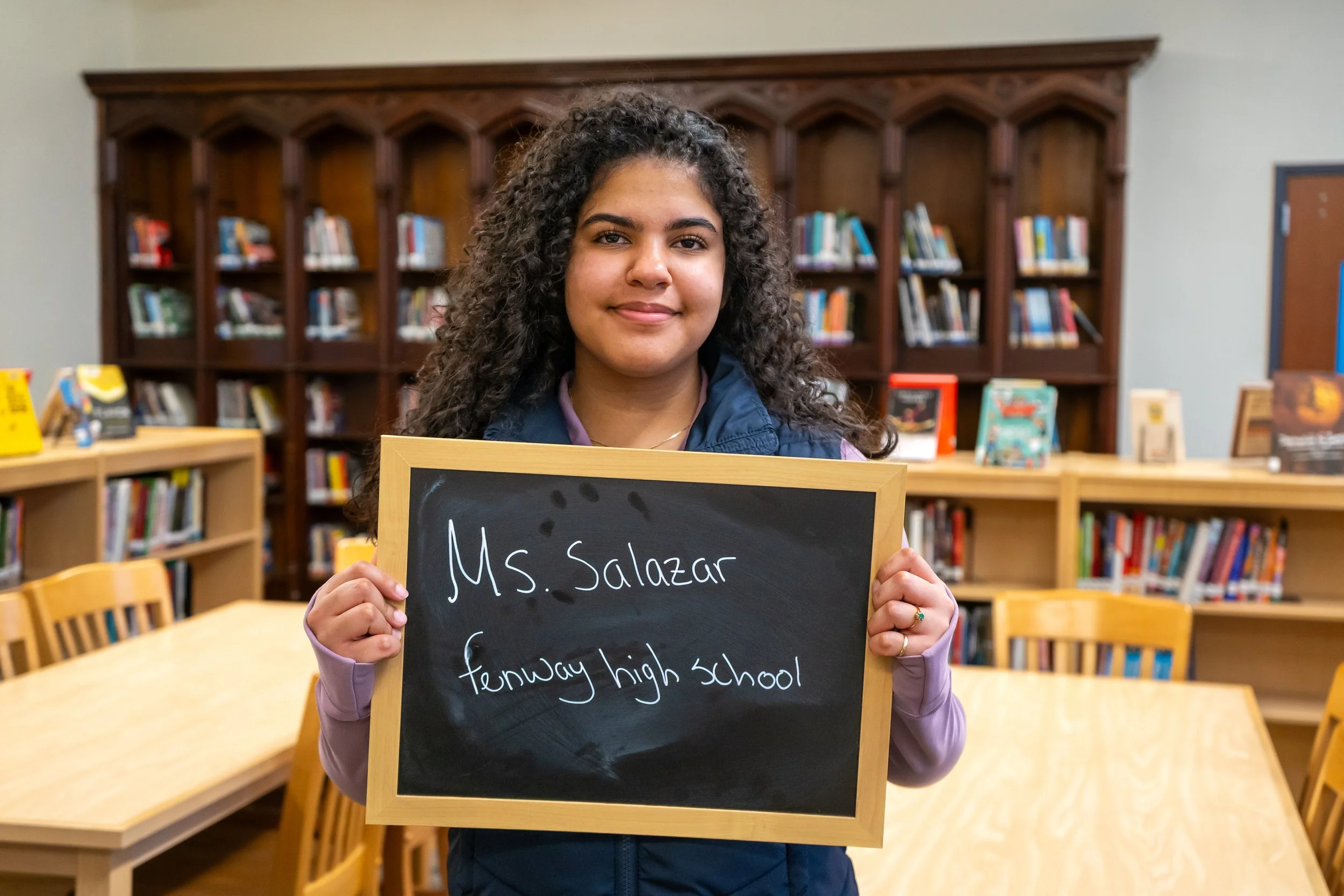 Boston student poses with a chalkboard.