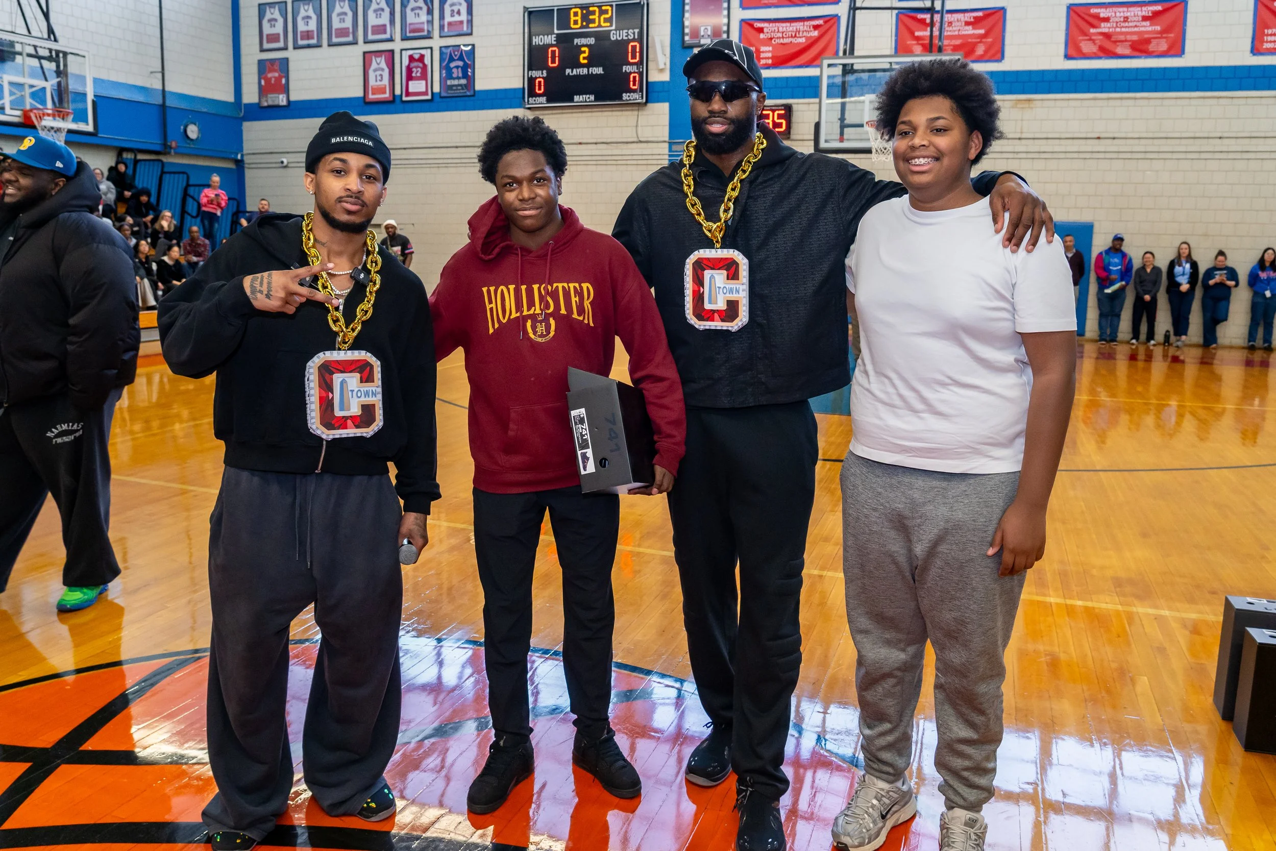 NBA Star and former Boston Celtics and current Philadelphia 76ers basketball player Jaylen Brown and streamer DDG pose with Charlestown High School students.