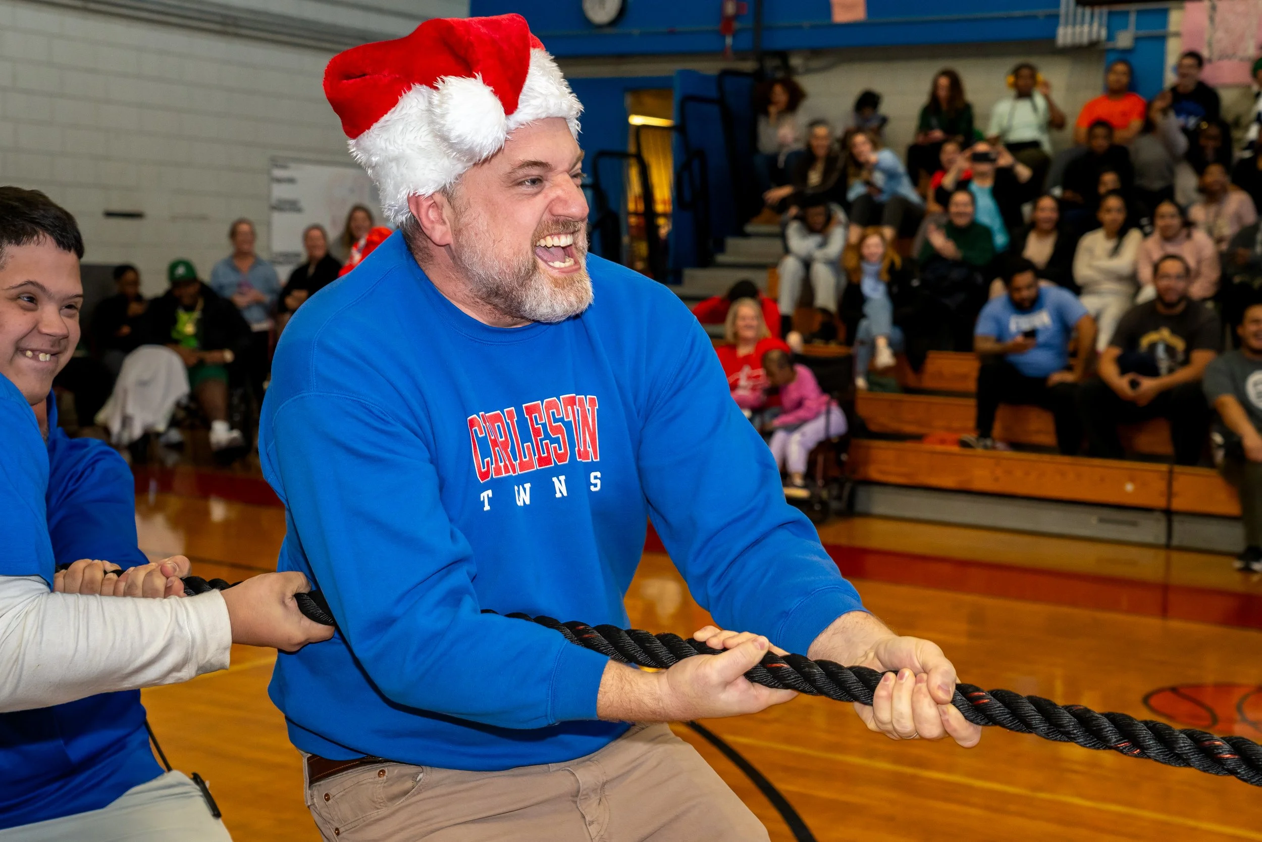 Charlestown High School staff member pulls a rope in a game of tug-of-war.