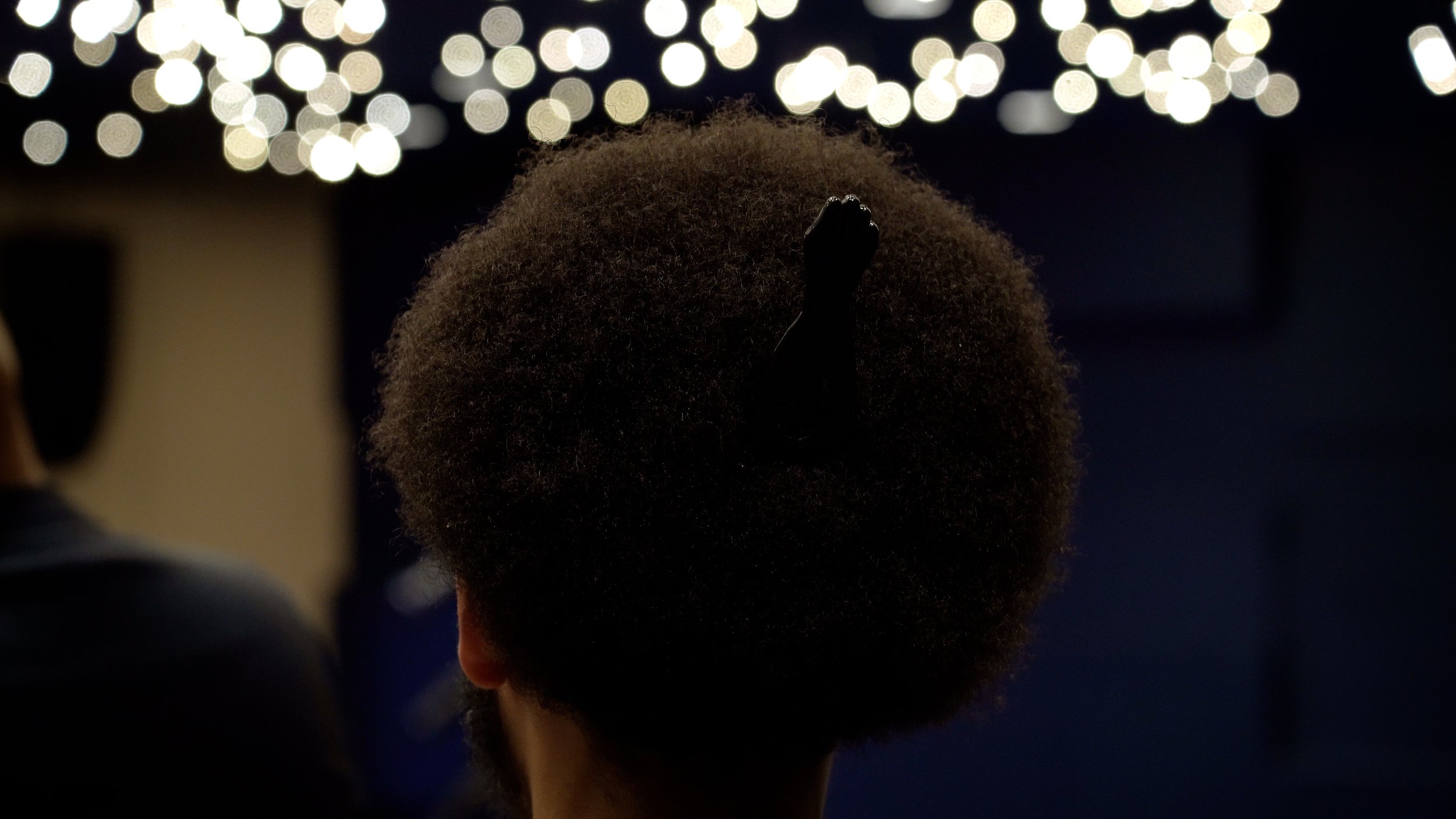 Close-up shot of Boston student Aaron Whyte Rios' hair and comb as he watches the City of Boston State of the Schools Address.