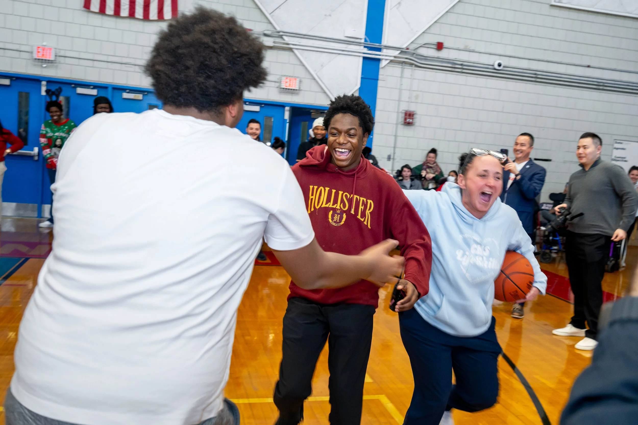 Charlestown High School student smiles and exclaims after he makes a basketball shot.