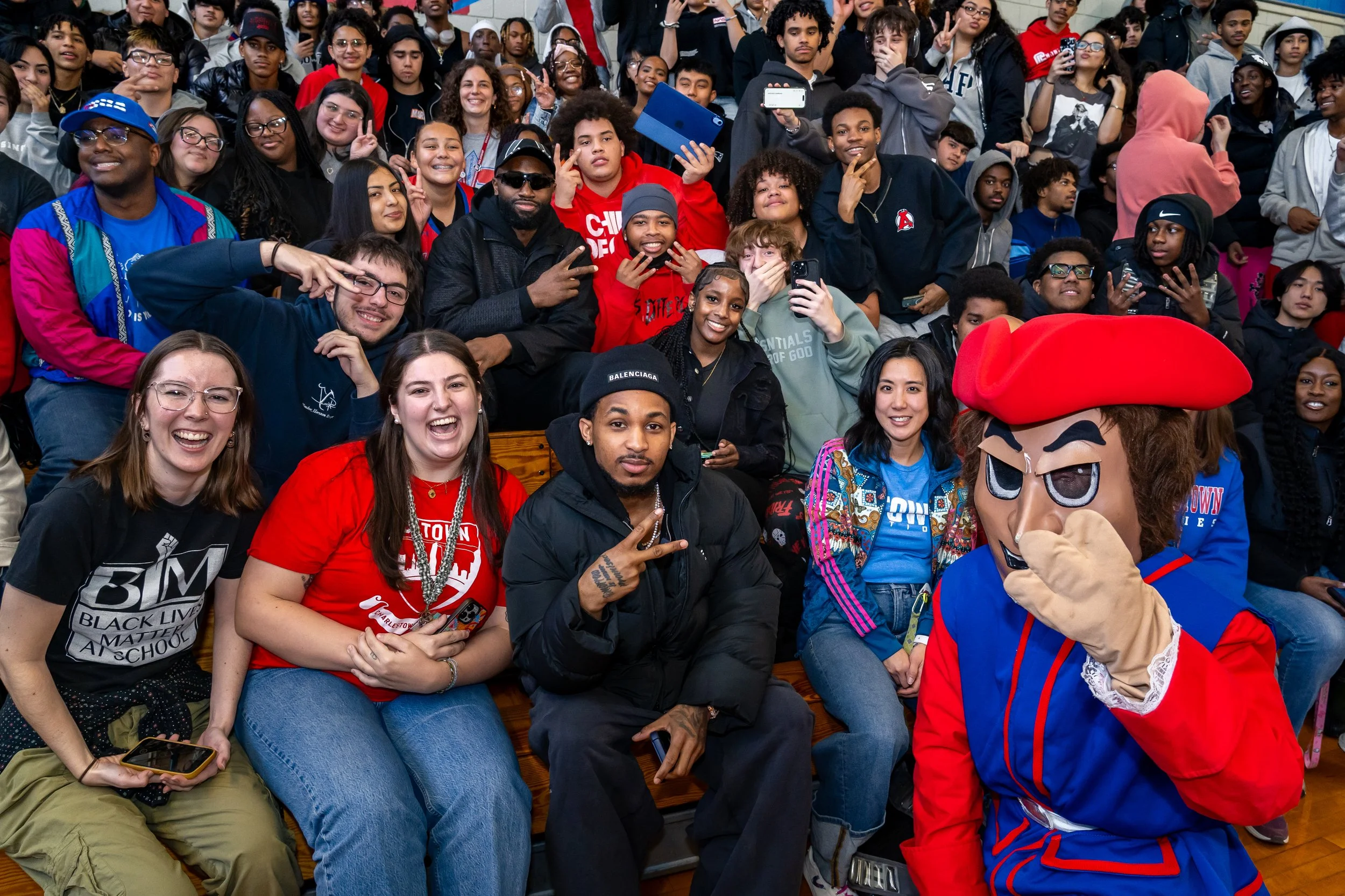 NBA Star and former Boston Celtics and current Philadelphia 76ers basketball player Jaylen Brown and streamer DDG pose with a group of Charlestown High School students.