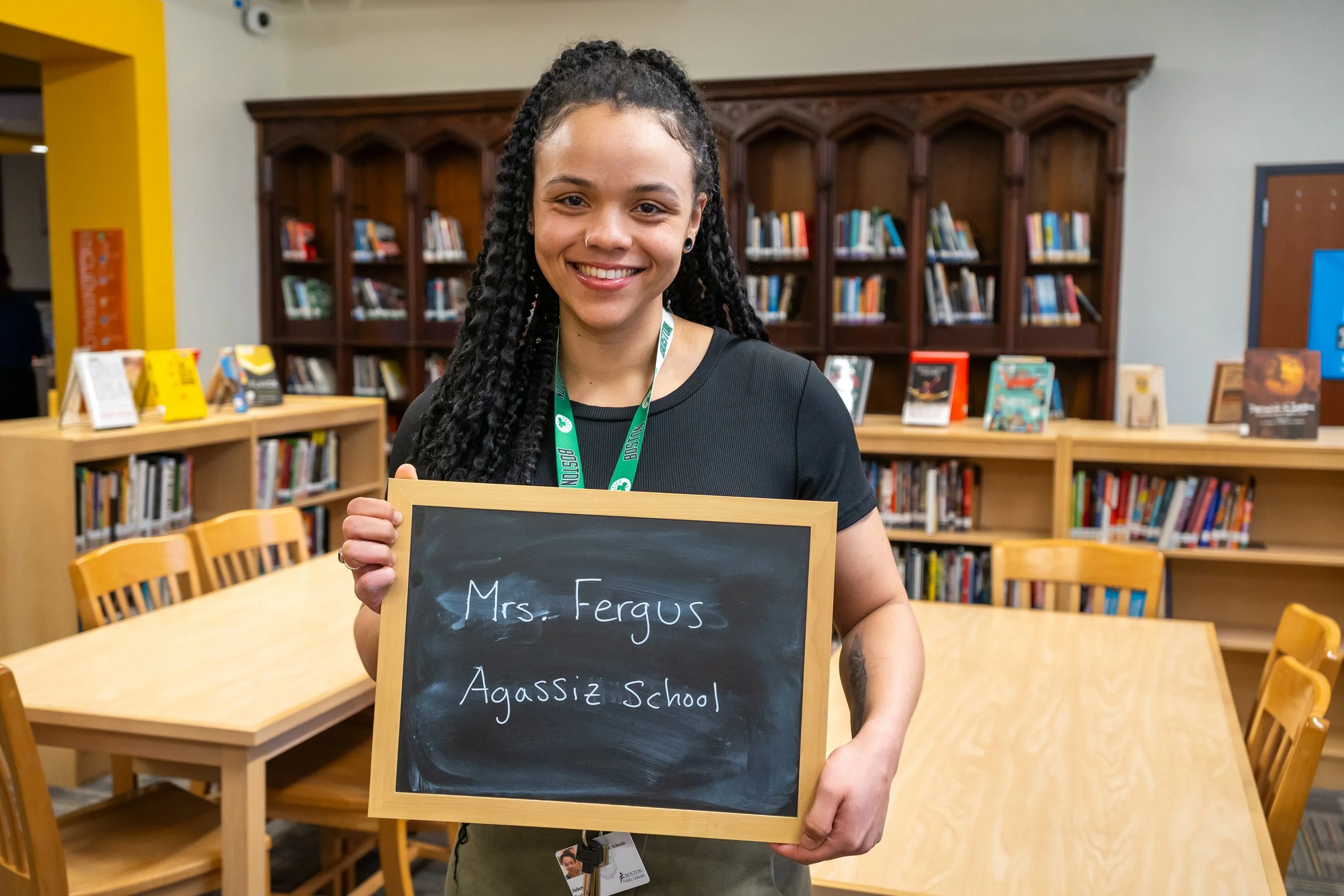 Fenway High School educator Juliette Rorie poses with a chalkboard with the name of a former teacher of hers written in chalk.