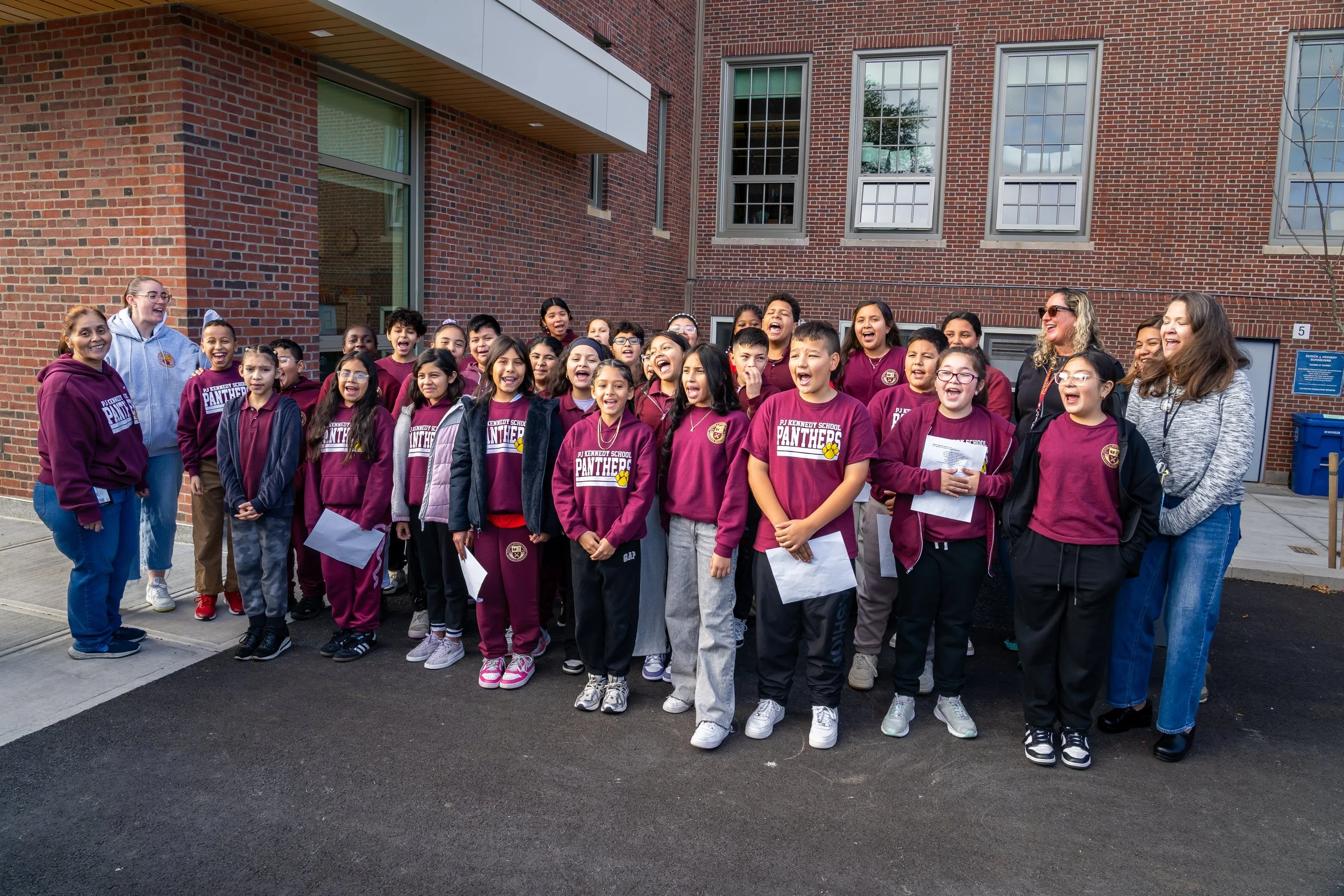 Large group of Patrick J Kennedy Elementary School students singing outside. 
