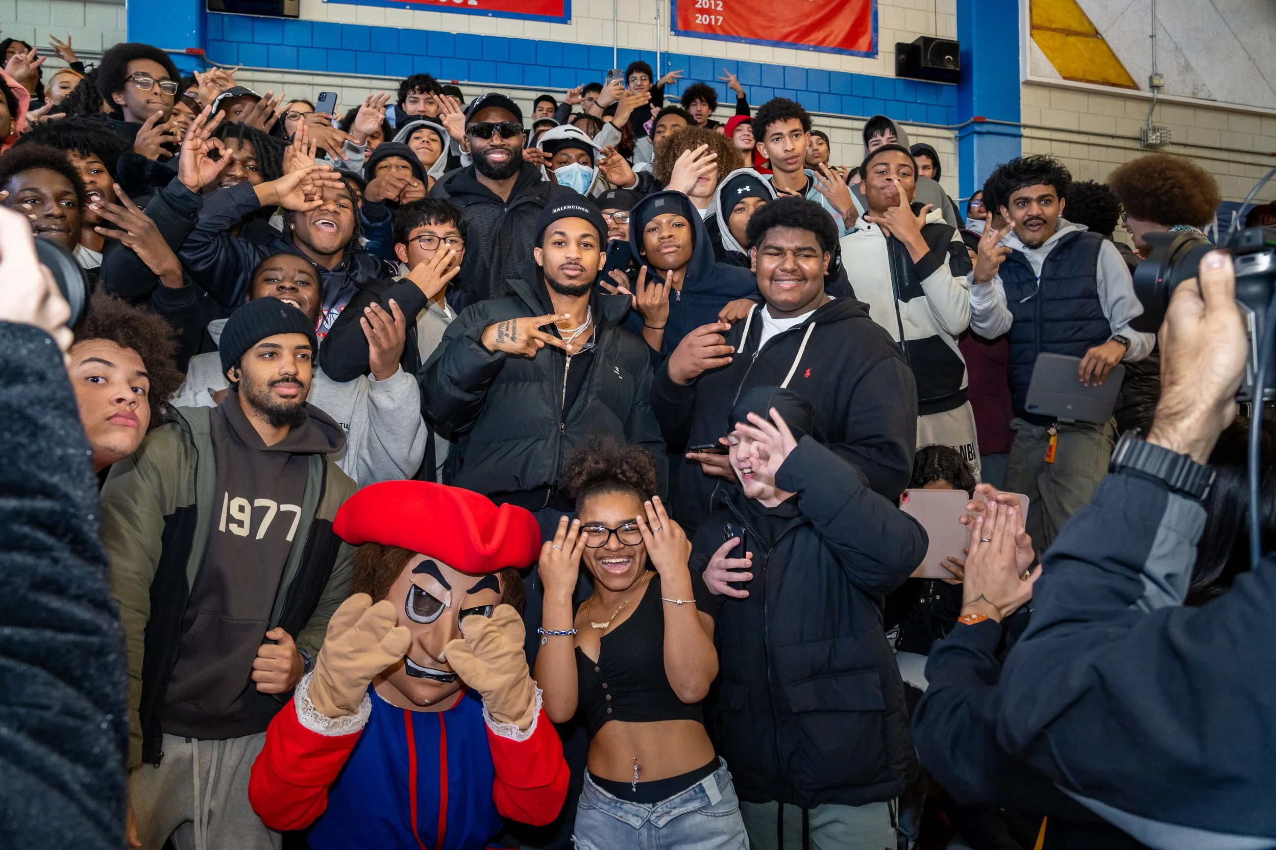 NBA Star and former Boston Celtics and current Philadelphia 76ers basketball player Jaylen Brown and streamer DDG pose with a group of Charlestown High School students.