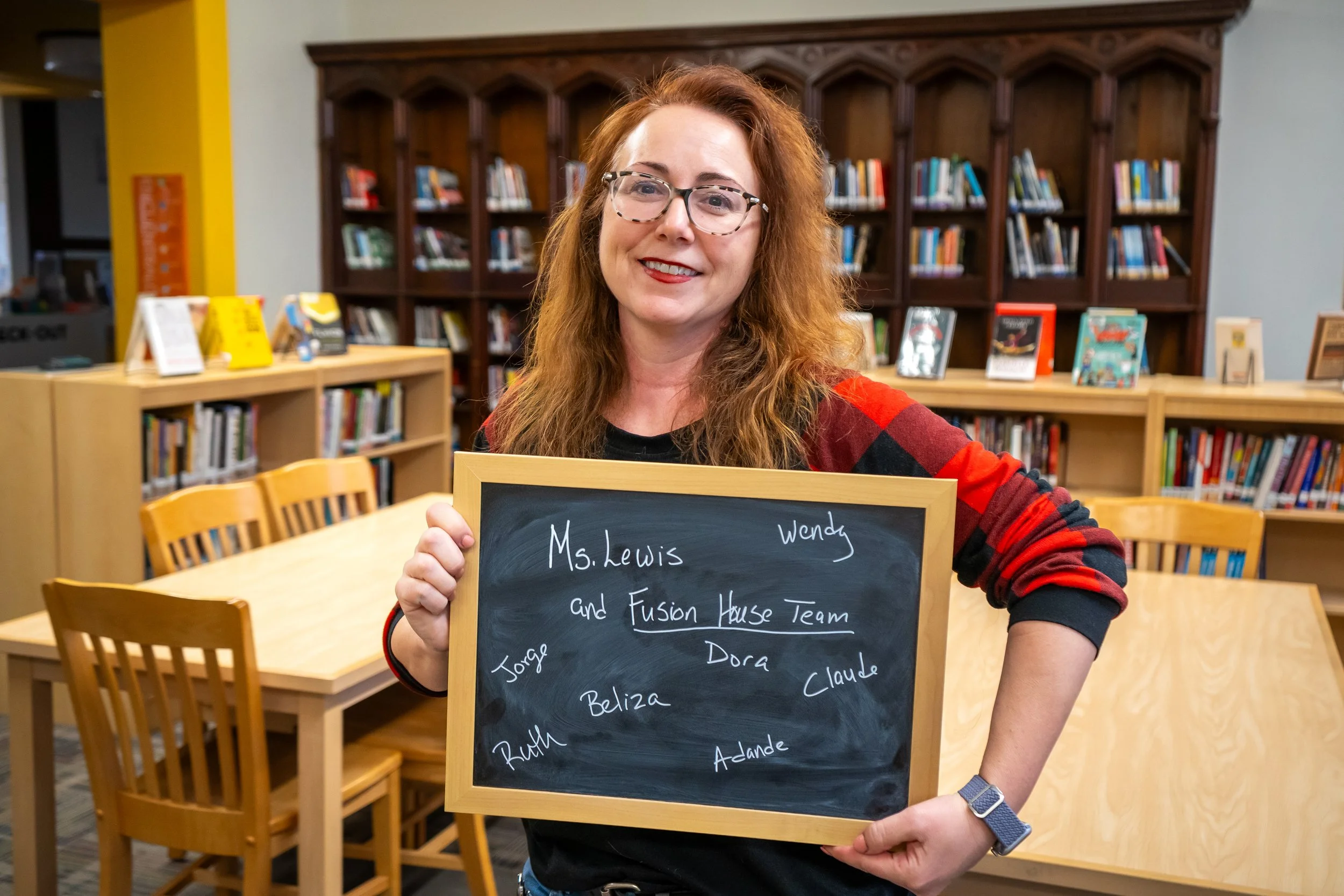 Boston educator poses with a chalkboard.