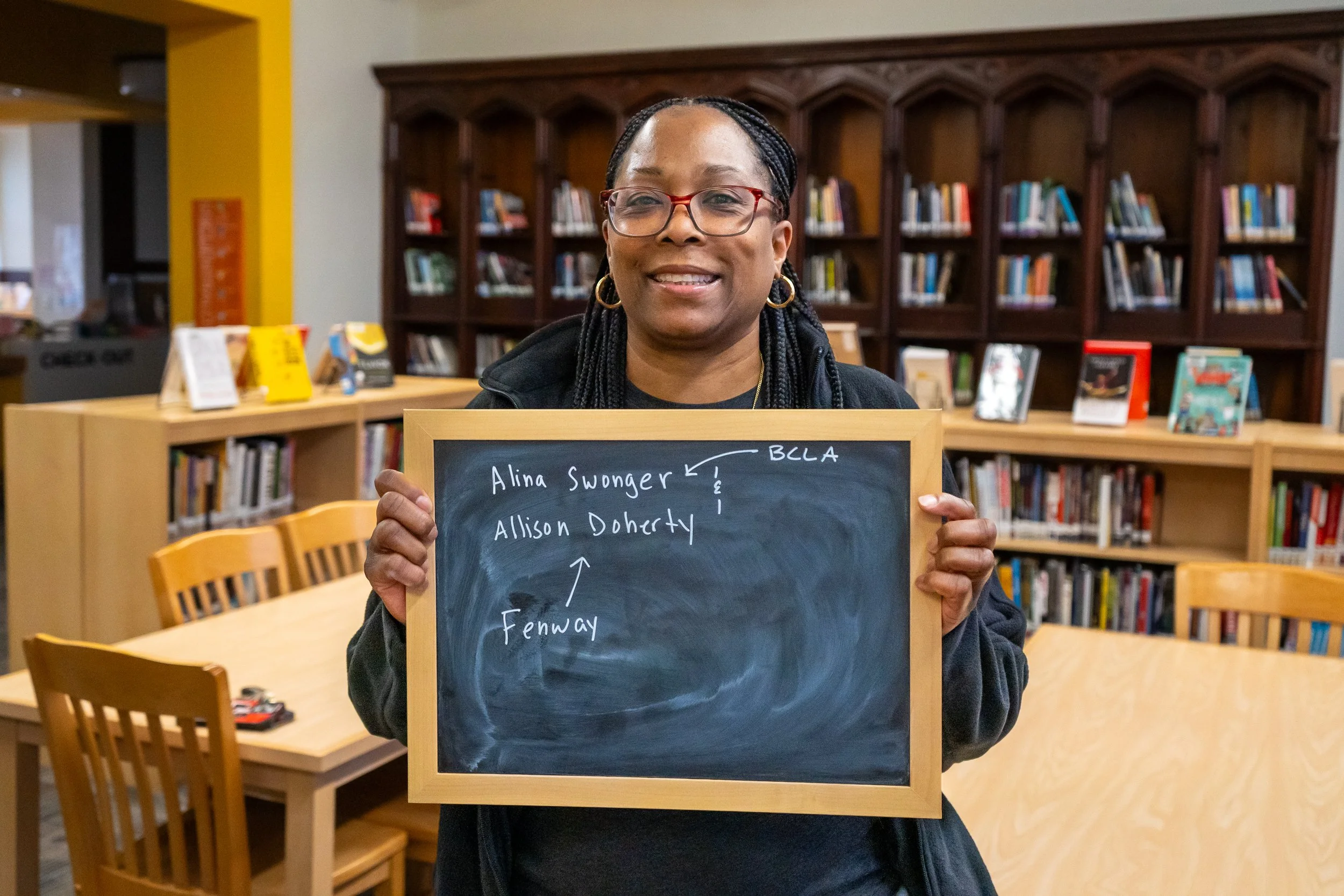 Boston educator poses with a chalkboard.