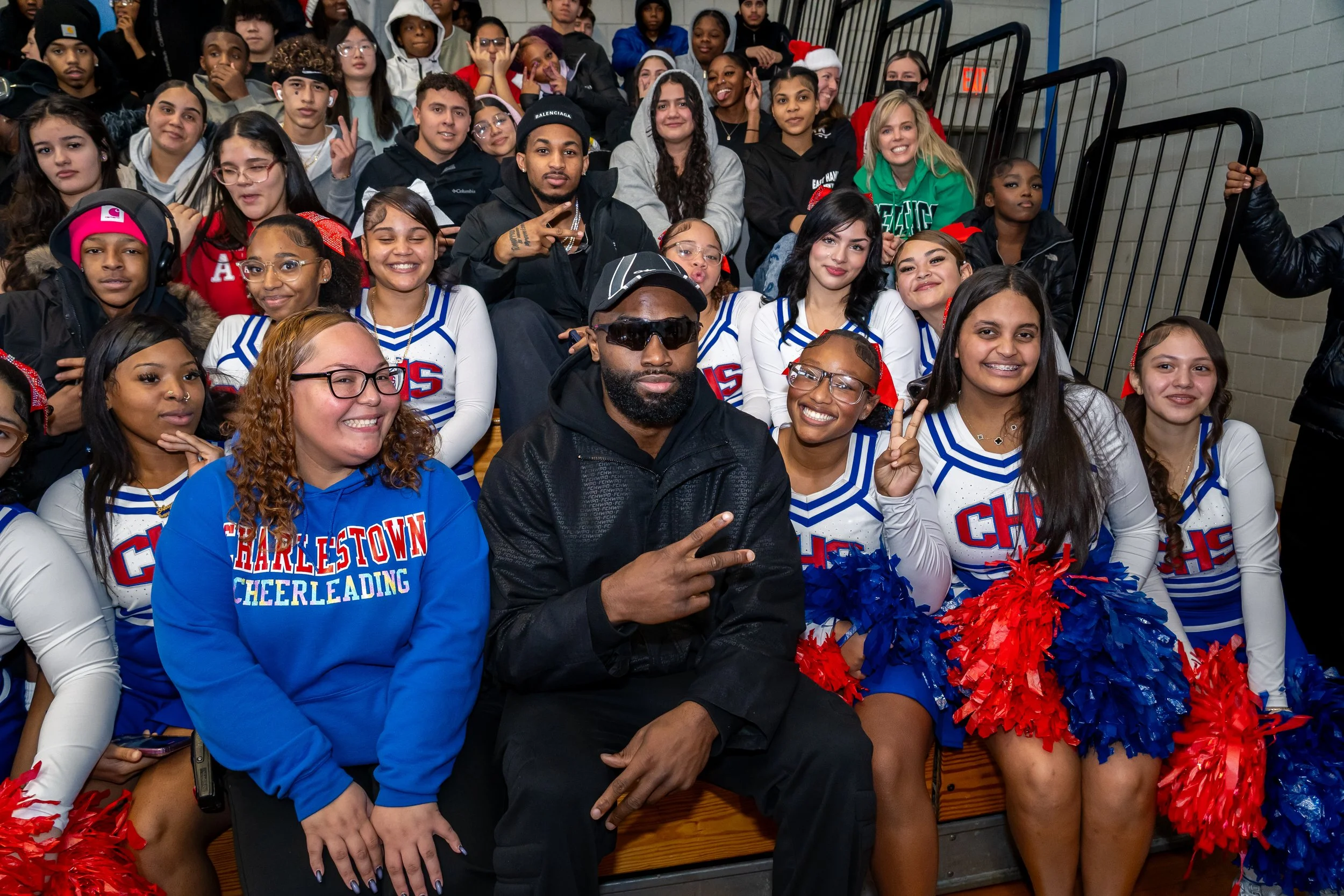 NBA Star and former Boston Celtics and current Philadelphia 76ers basketball player Jaylen Brown and streamer DDG pose with a group of Charlestown High School students.