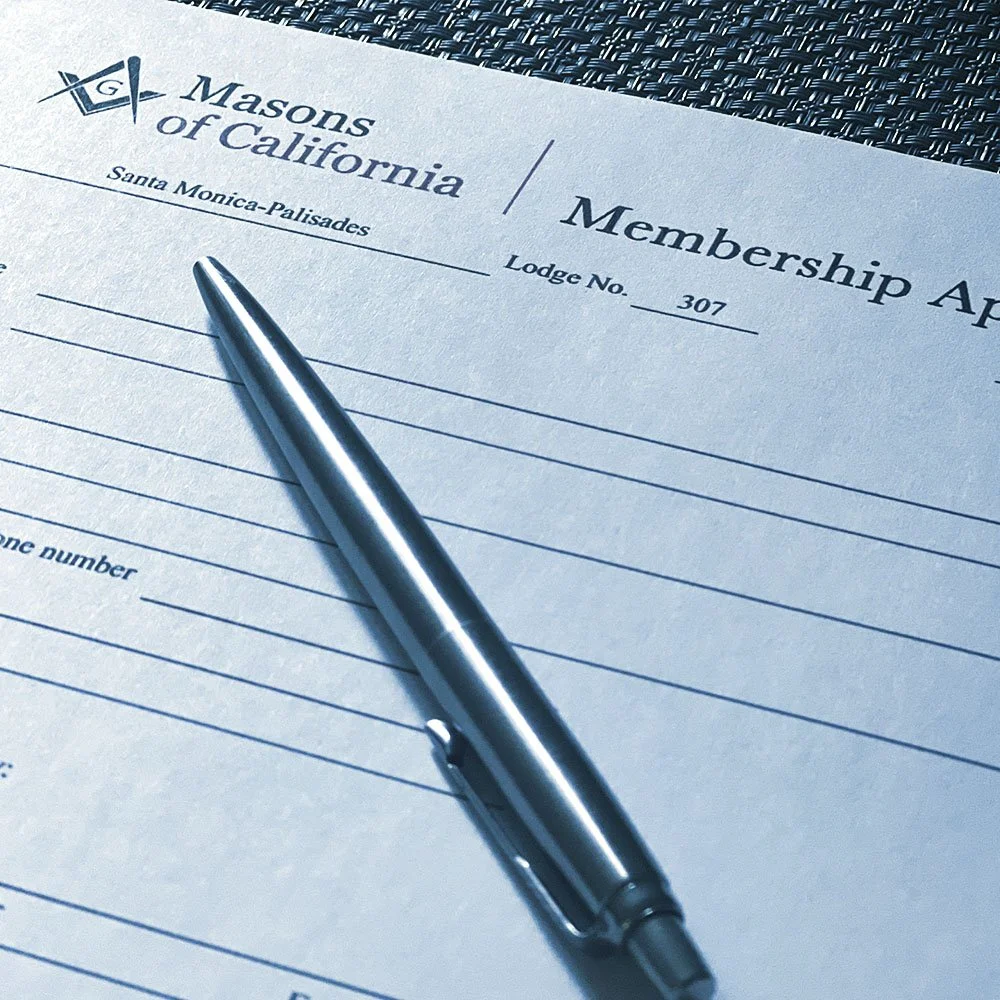A membership application form for Masons of California, specifically for Santa Monica-Palisades lodge number 307, with a silver pen on top of the form.