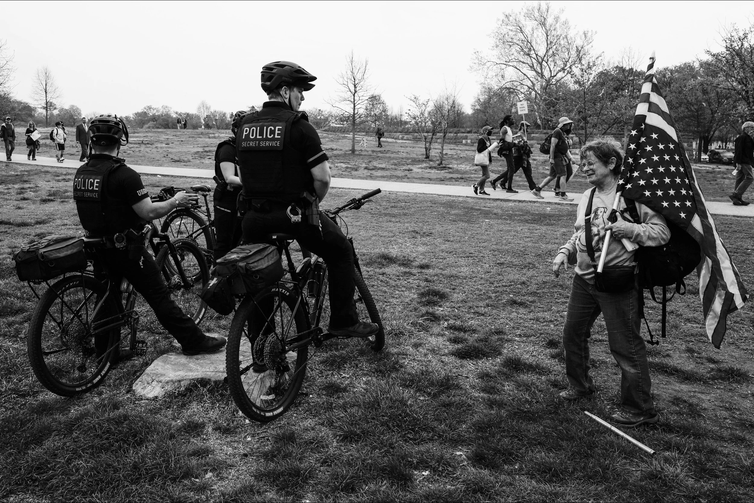 A woman speaks to DC Metro police holding an inverted American flag at the April 5 protest at the capitol, April 5 2025