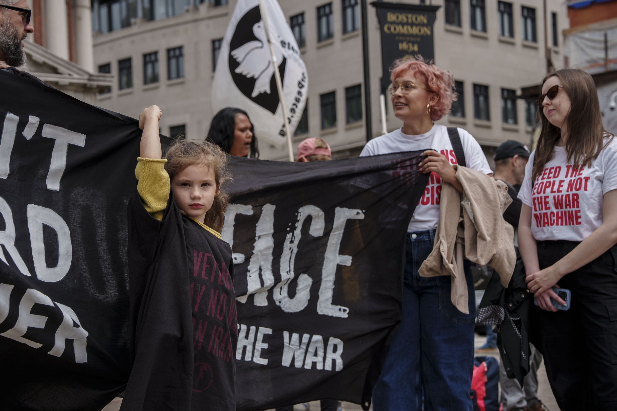 A child holds up a sign at a veterans for peace event in the Boston Common on May 25, 2026