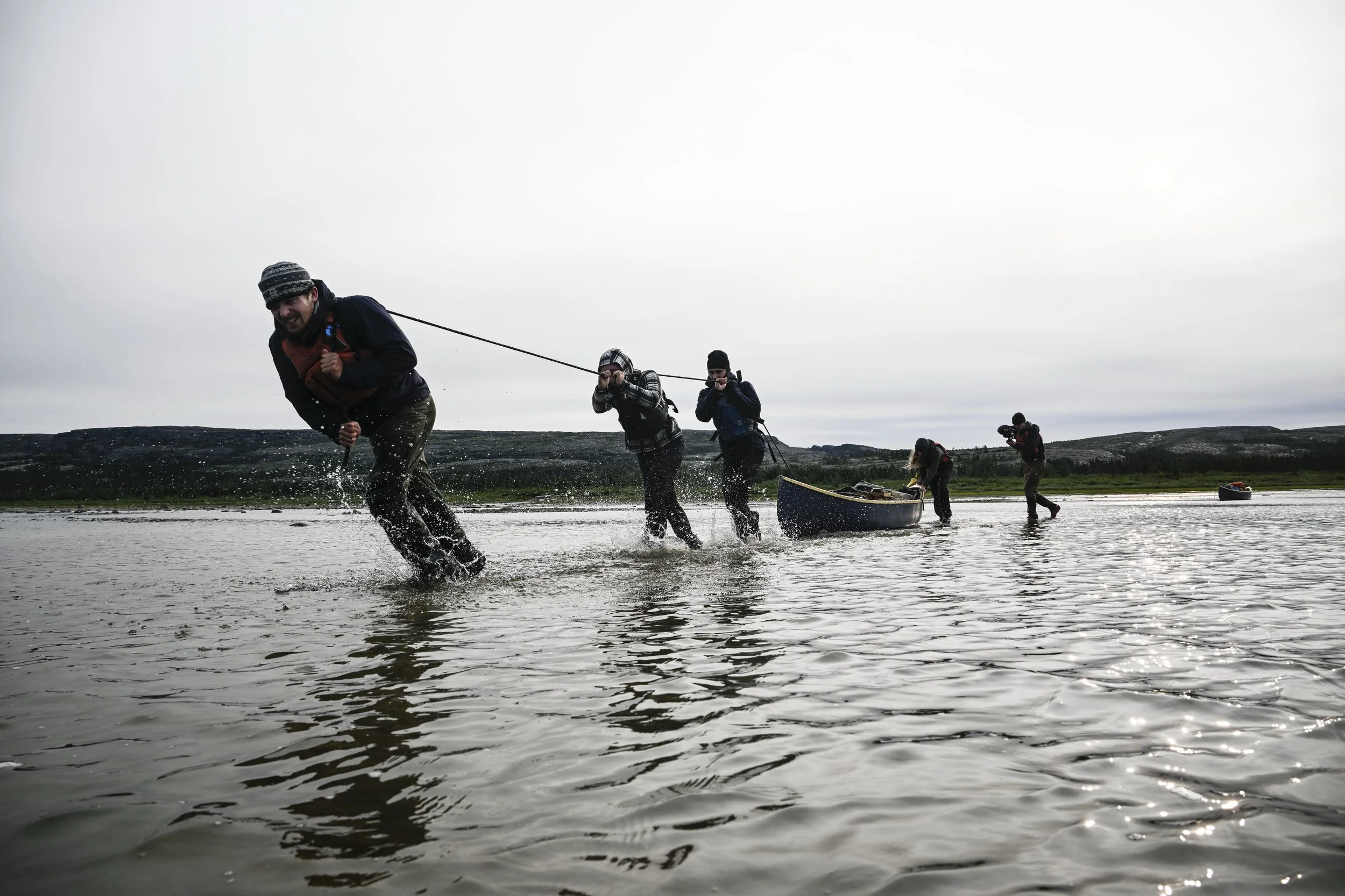 From left, Duncan Grant, Erica Wilson, Nils Missillier, Jasmin MacDonald and Miles Gordon drag a 400-pound wooden canoe across a shallow sandbar during the final stage of a 45-day, 700-kilometer expedition through northern Quebec. The team traveled f
