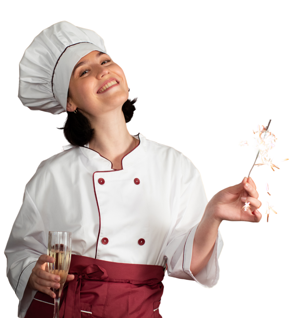A woman dressed as a chef smiling and holding a sparkler in one hand and a glass of champagne in the other.