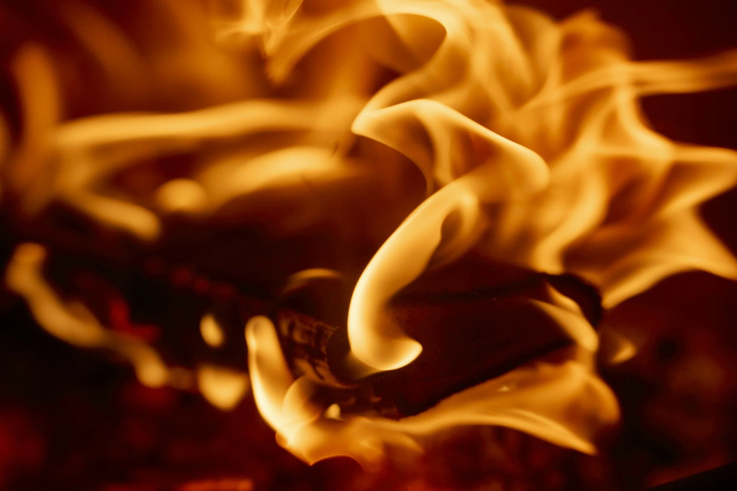 Close-up of orange and yellow flames with fiery, swirling patterns.