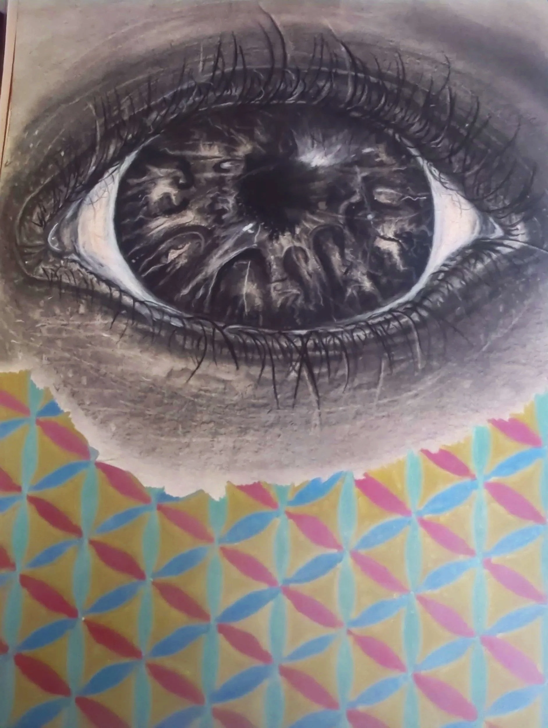 A detailed black and white drawing of a human eye, focusing on the iris, eyelashes, and surrounding skin with colorful, flower of life pattern at the bottom.