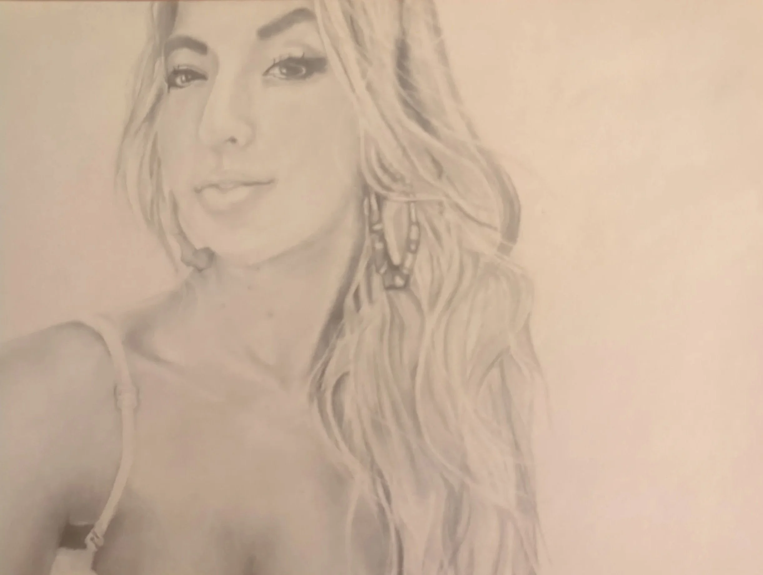 A pencil sketch of a woman's face with long, wavy hair and expressive eyes.