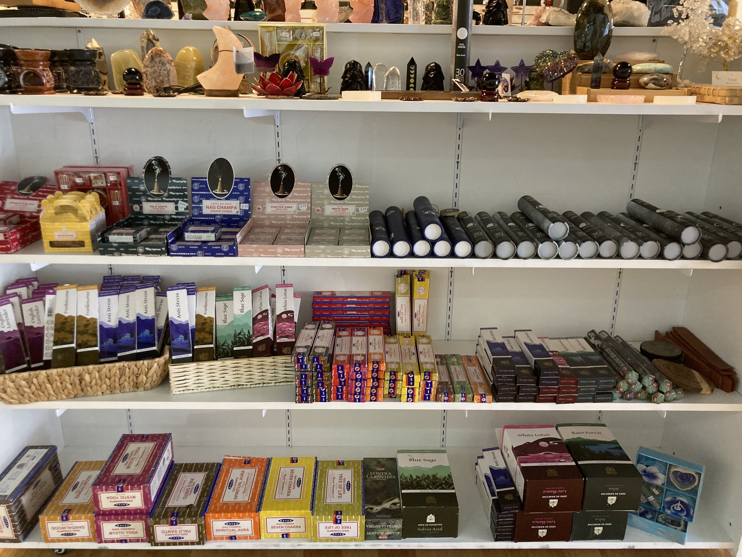 Display of various spiritual and health products on store shelves, including chakra cones, herbal remedies, and decorative items.