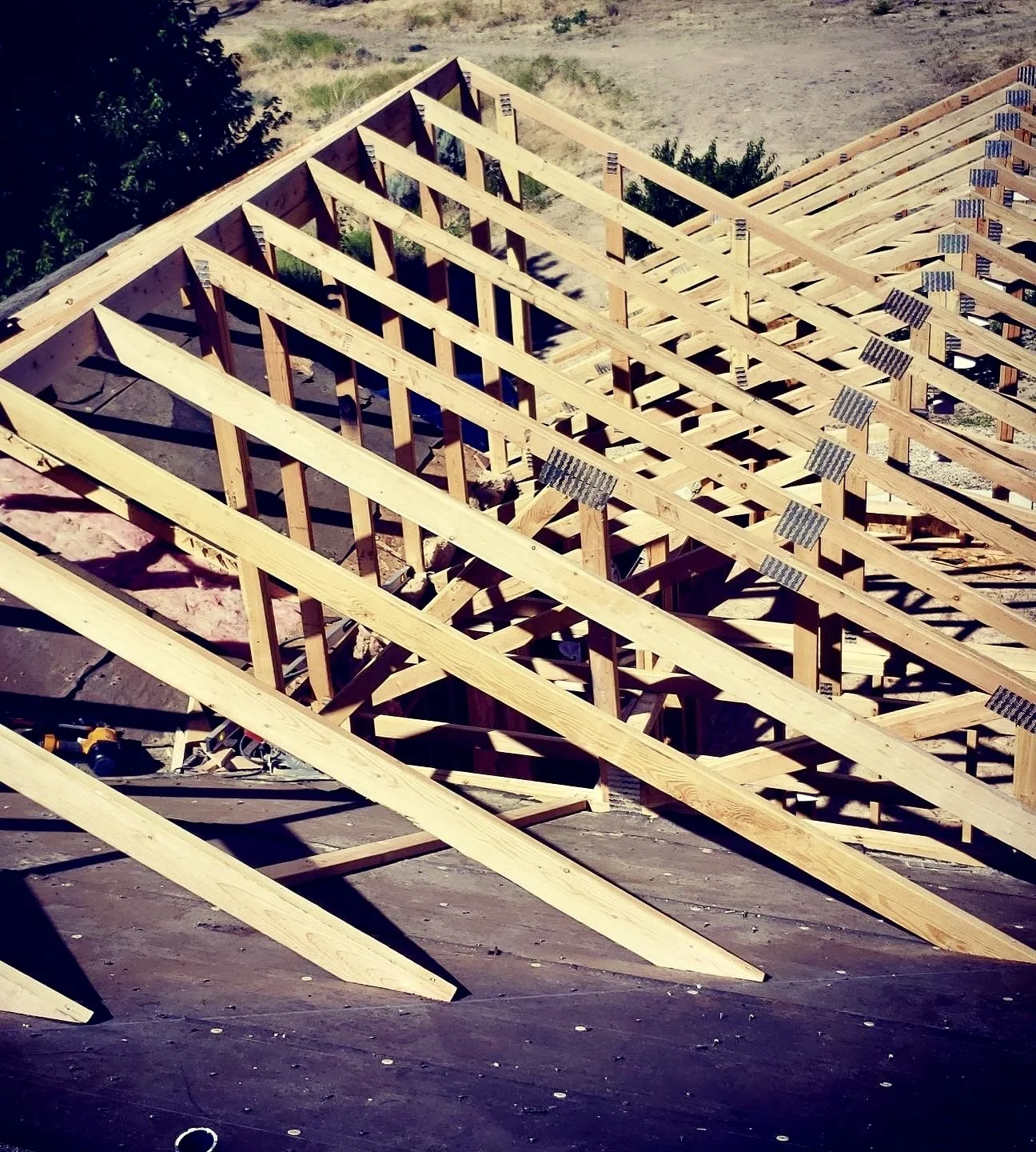 Wooden roof trusses being installed on a building under construction.