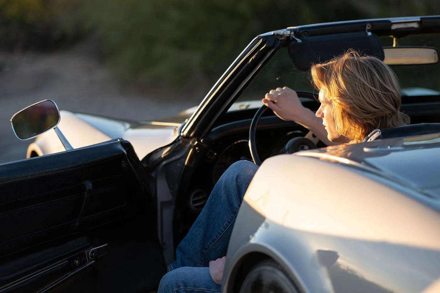 a tucson high school senior looks into the distance from a classic car during a photo shoot