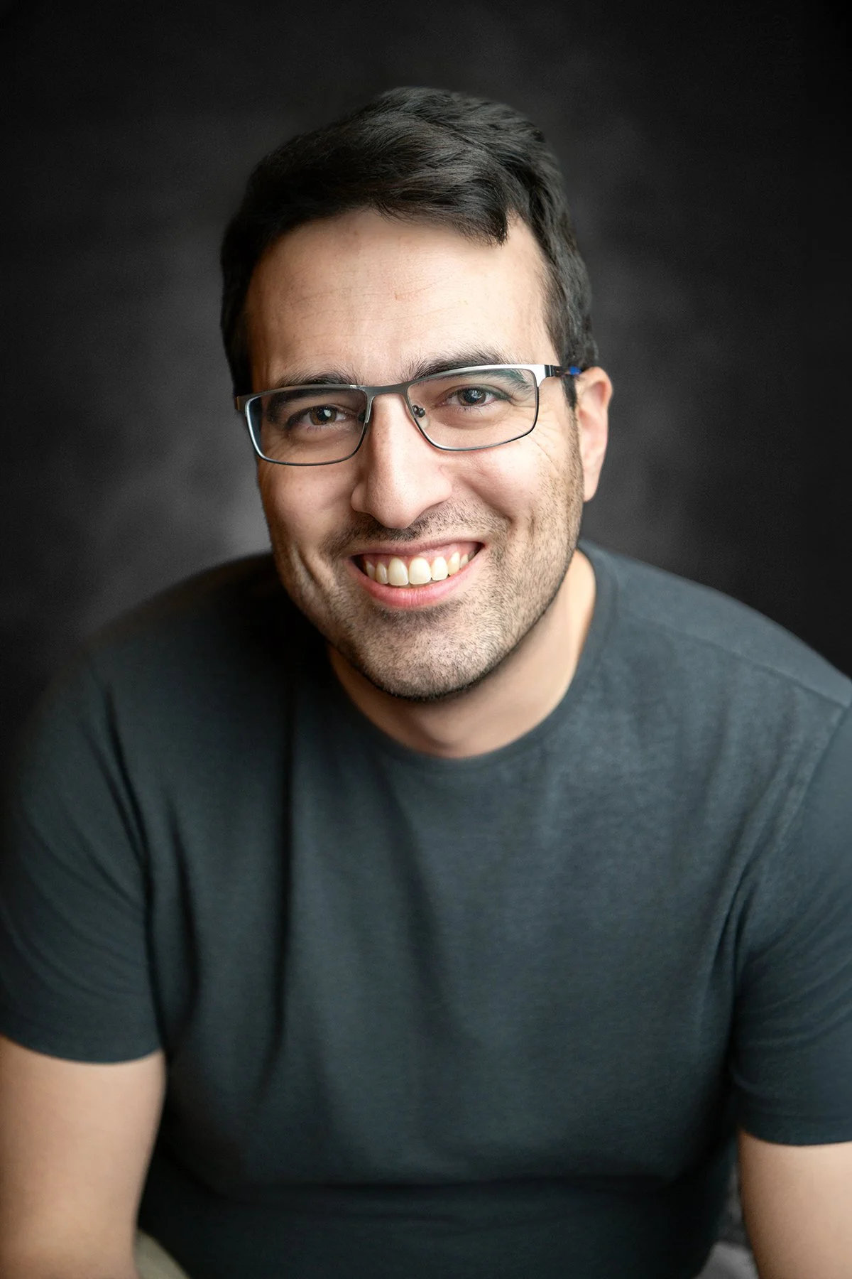 a man wearing glasses poses for a headshot in tucson arizona