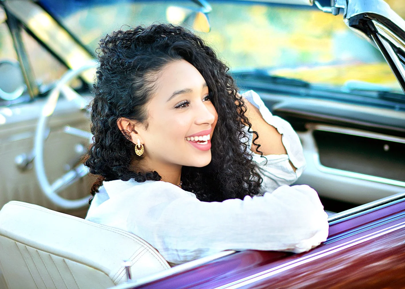 an energetic tucson high school senior girl poses in a classic car