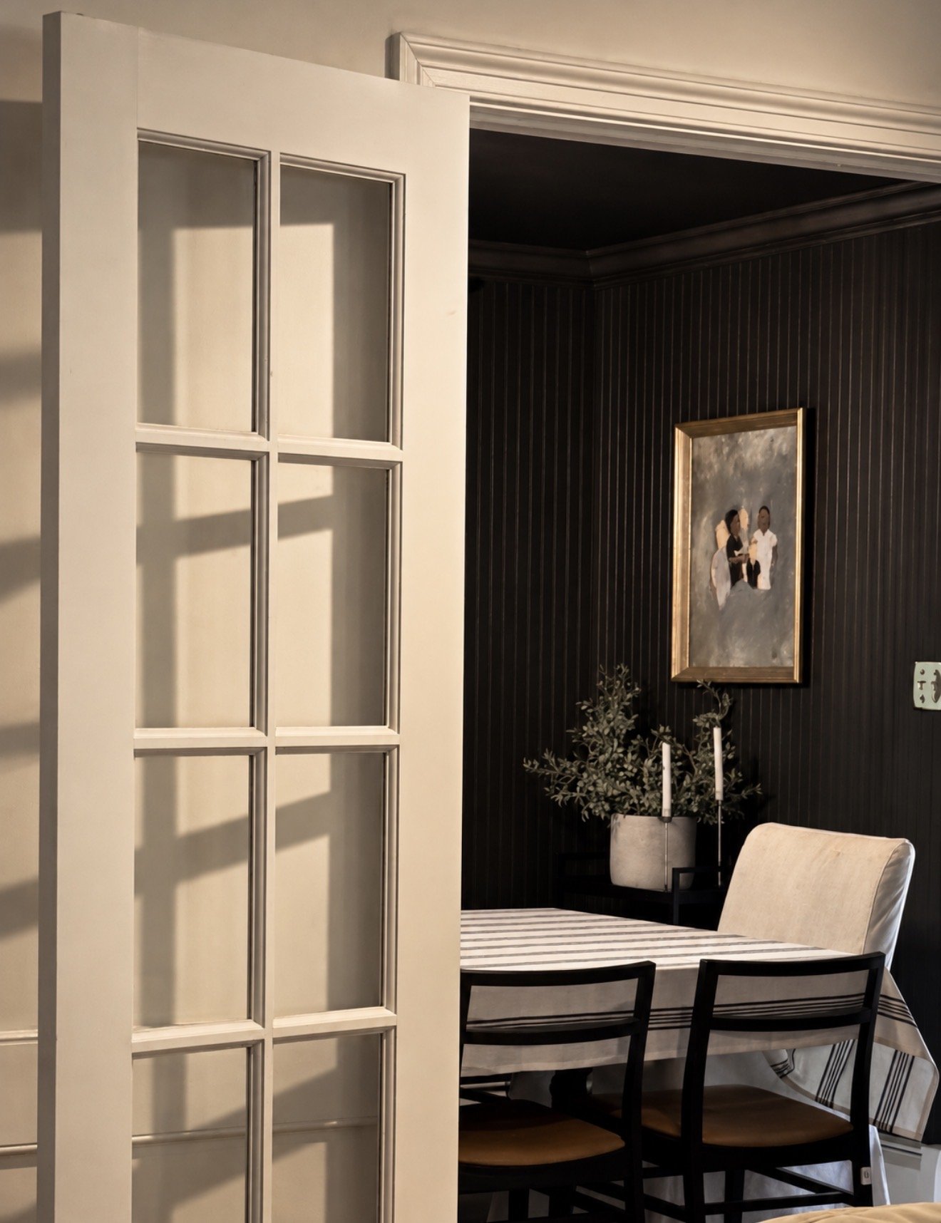 French door opening to a dark-walled dining room in a Main Line home