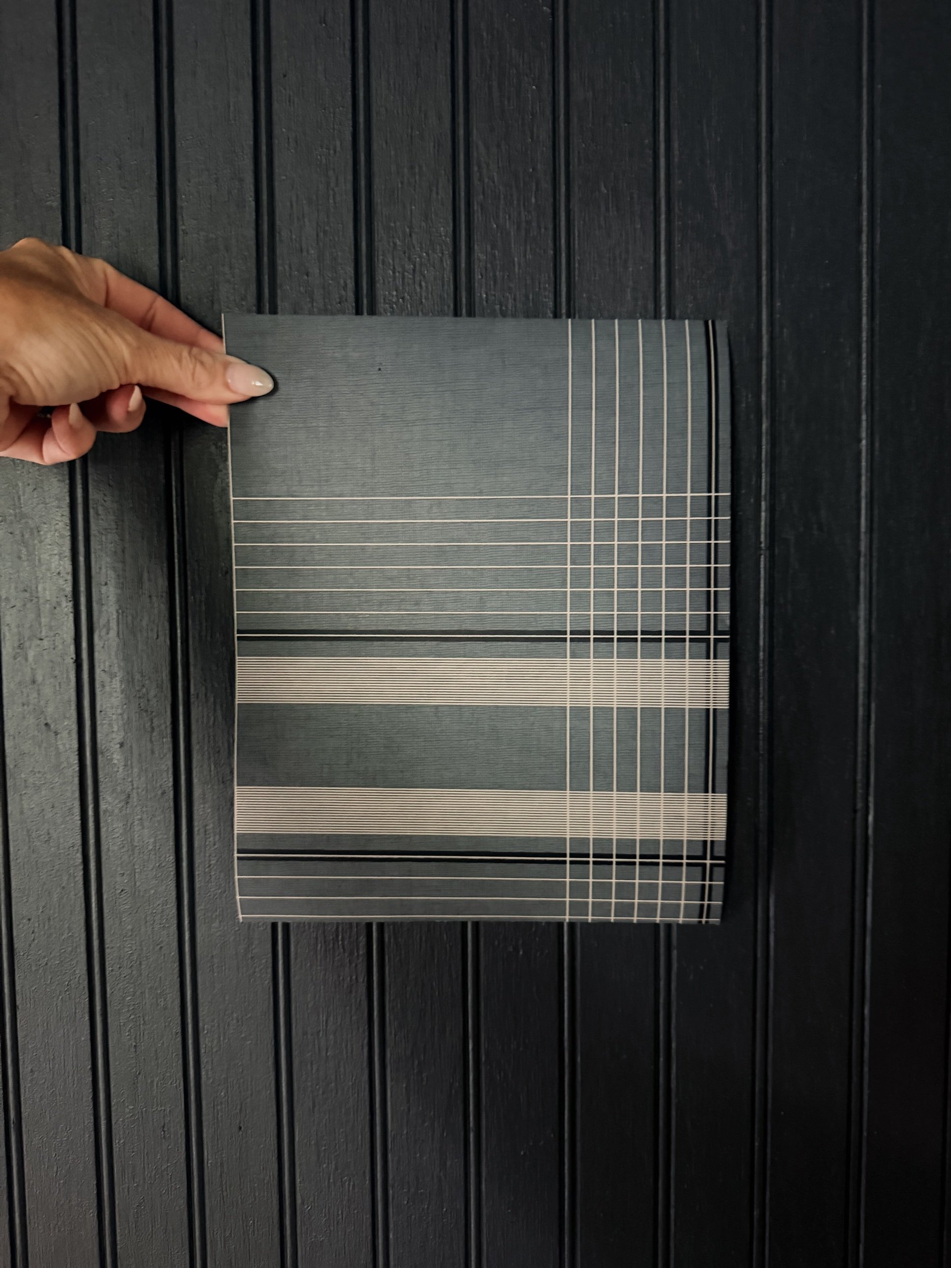 Plaid fabric sample held against black beadboard
