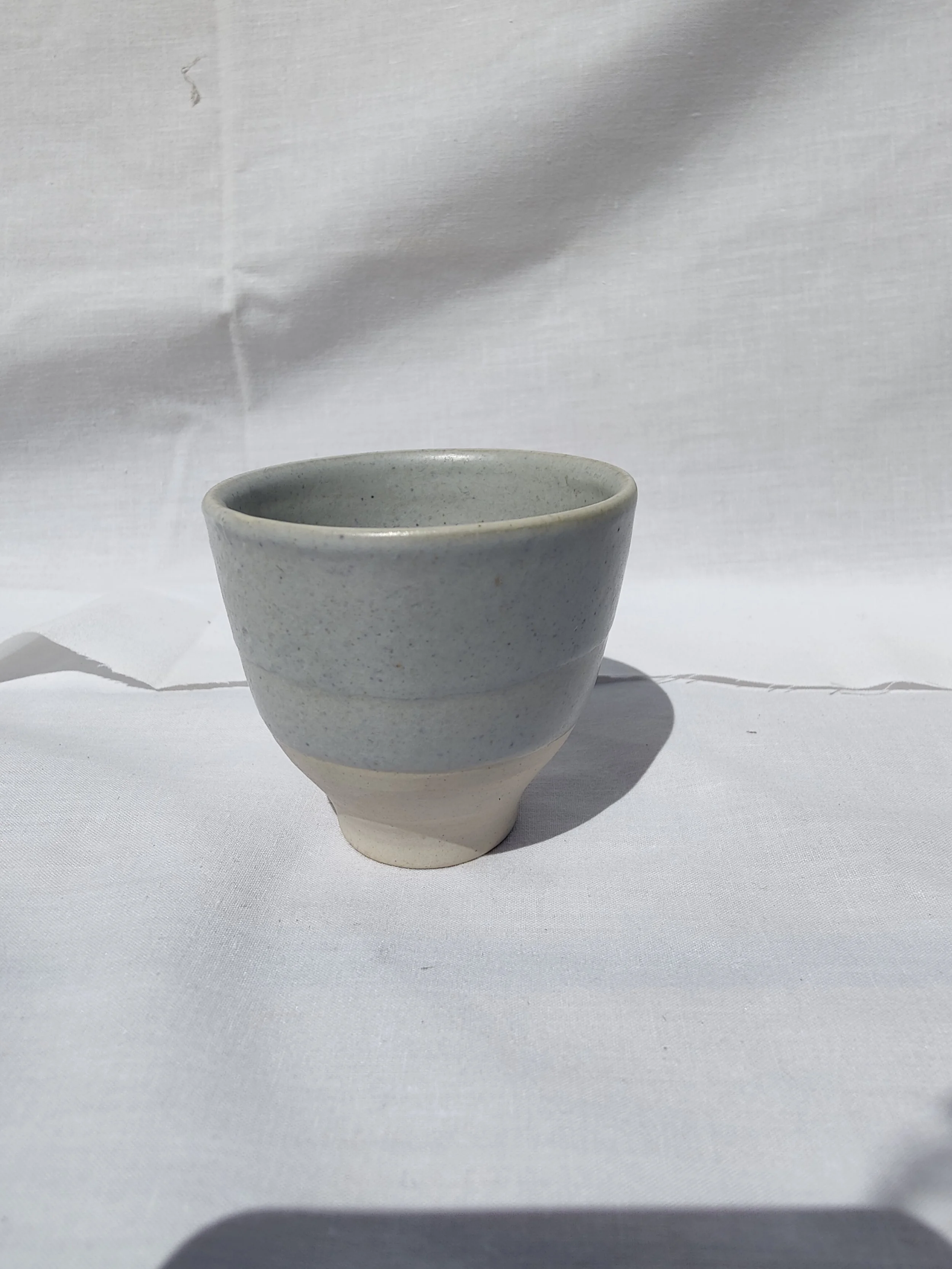 Gotets de tast de cafè i te de gres blanc amb diversos esmalts acolorits (blau, verd, gris) i base al natural, fets a mà per Ceràmiques PasVi a La Bisbal d'Empordà.