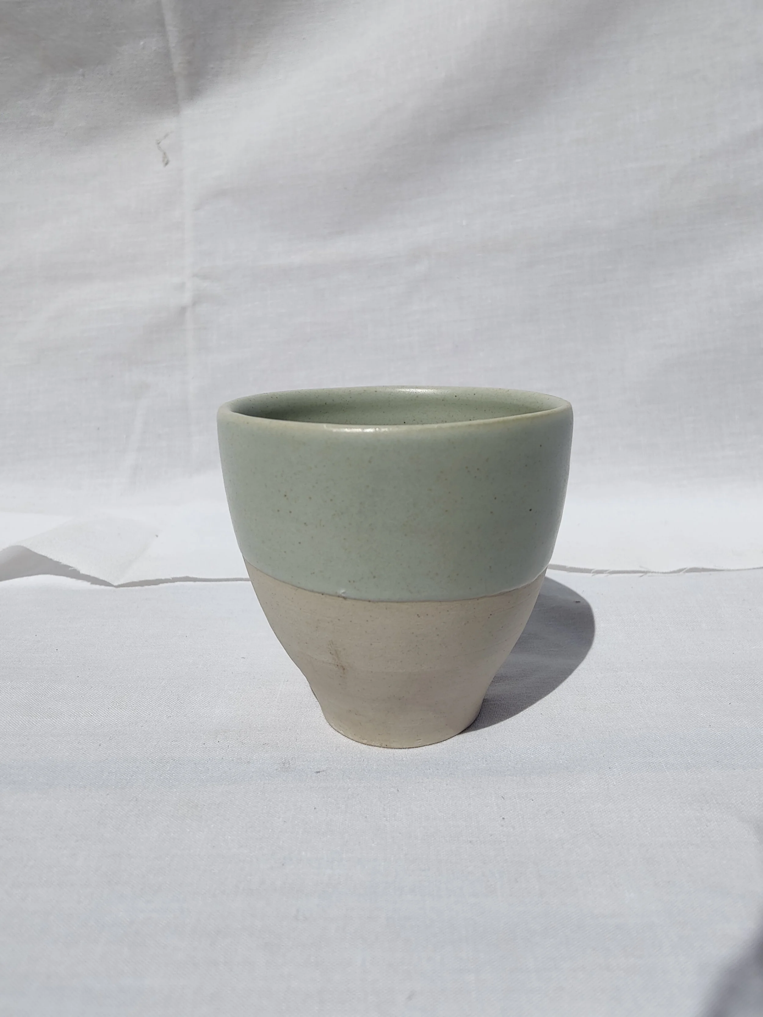 Gotets de tast de cafè i te de gres blanc amb diversos esmalts acolorits (blau, verd, gris) i base al natural, fets a mà per Ceràmiques PasVi a La Bisbal d'Empordà.