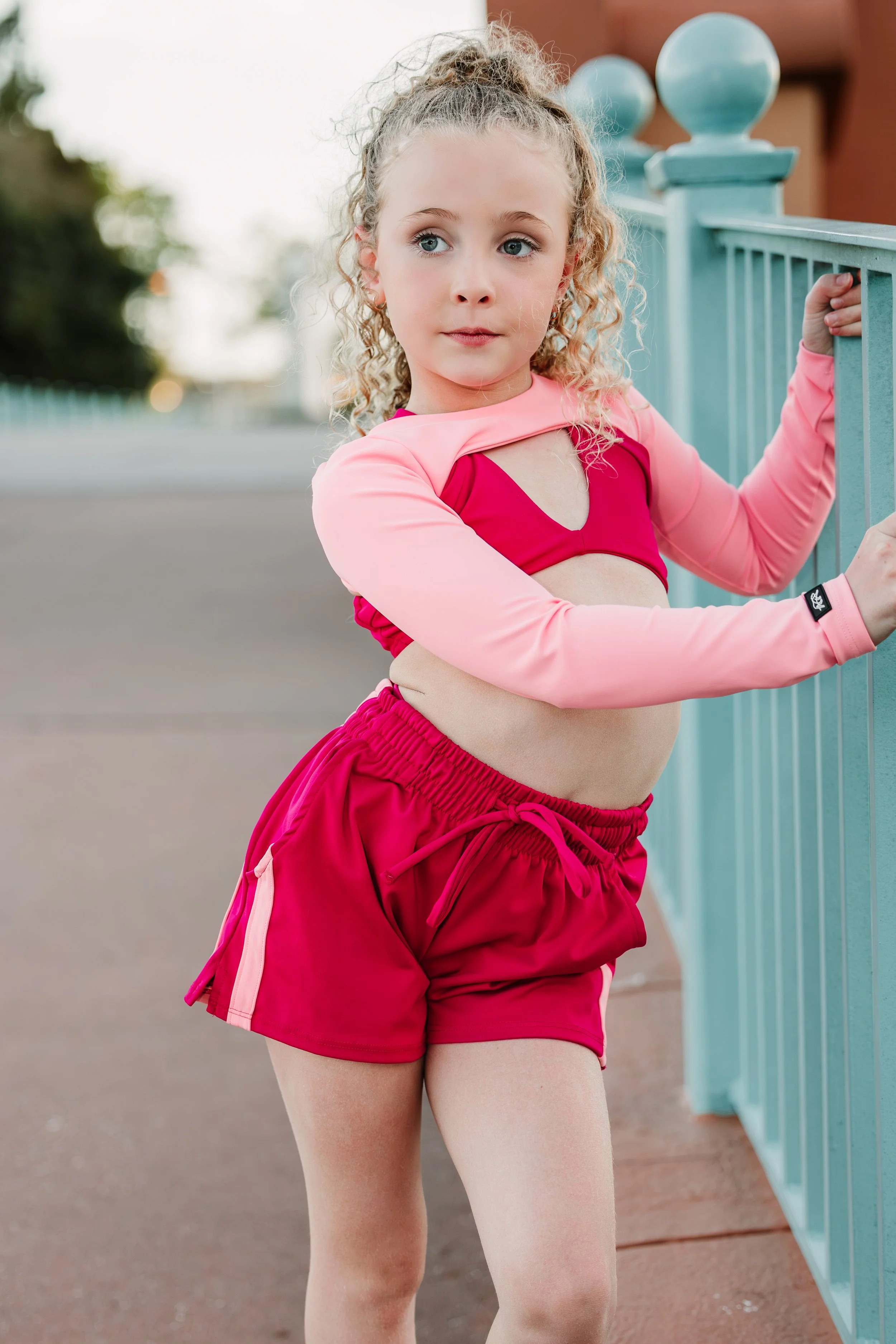A young girl with curly blonde hair tied in a high ponytail, wearing Tiger Friday Dancewear - Orlando dance photography.