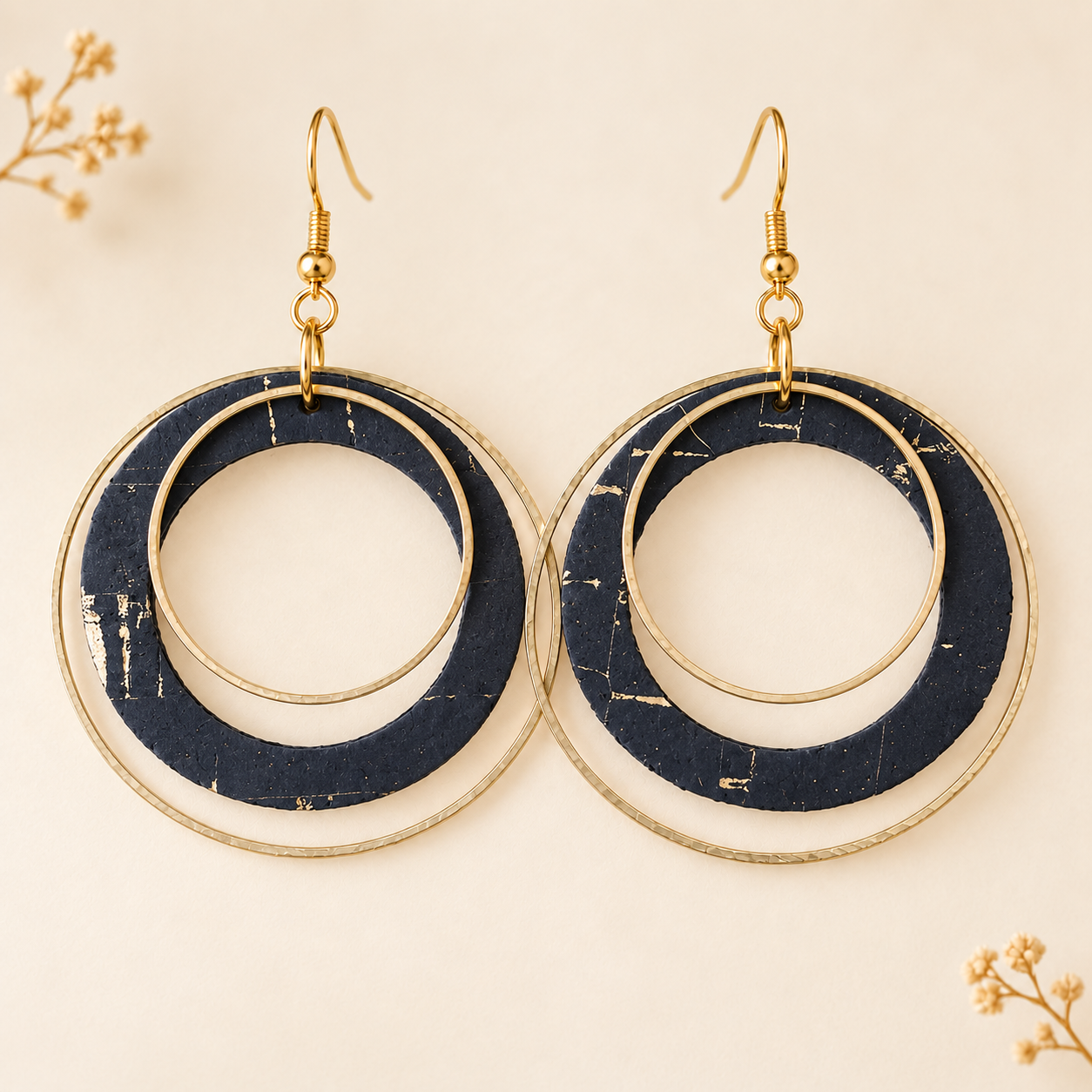 Black and gold cork fabric earrings with overlapping gold color hoops.