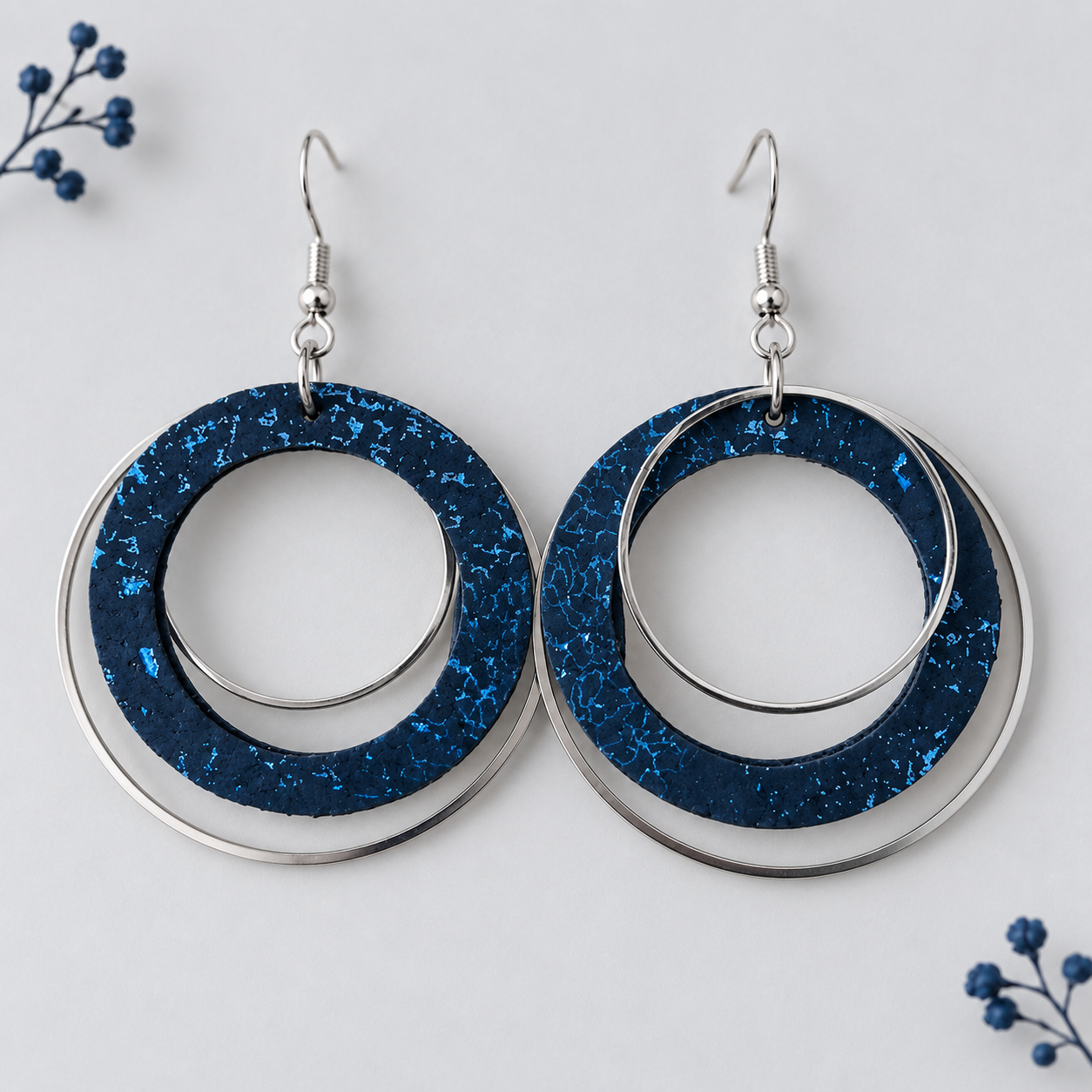 Midnight blue cork fabric earrings with blue flecks and overlapping silver color  hoops.