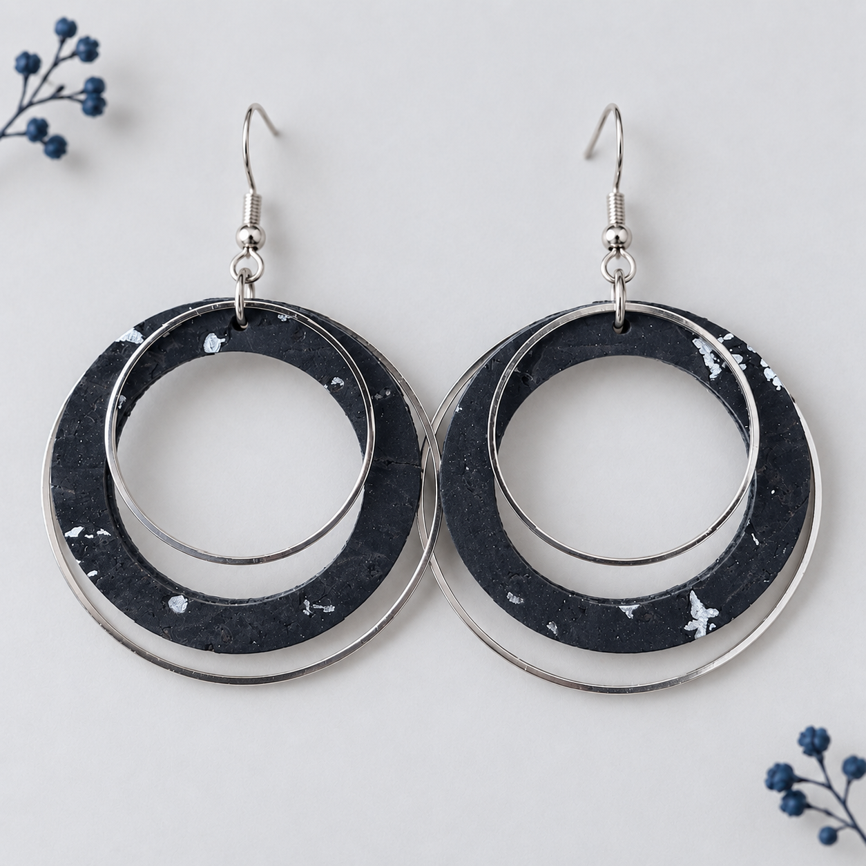 Black and silver cork fabric earrings with overlapping silver color hoops.