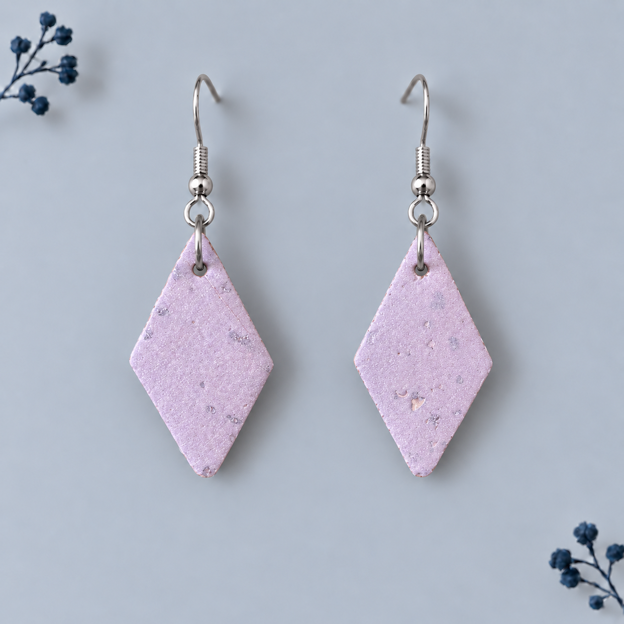 Earrings with diamond shaped rose gold colored cork fabric and silver colored hooks.