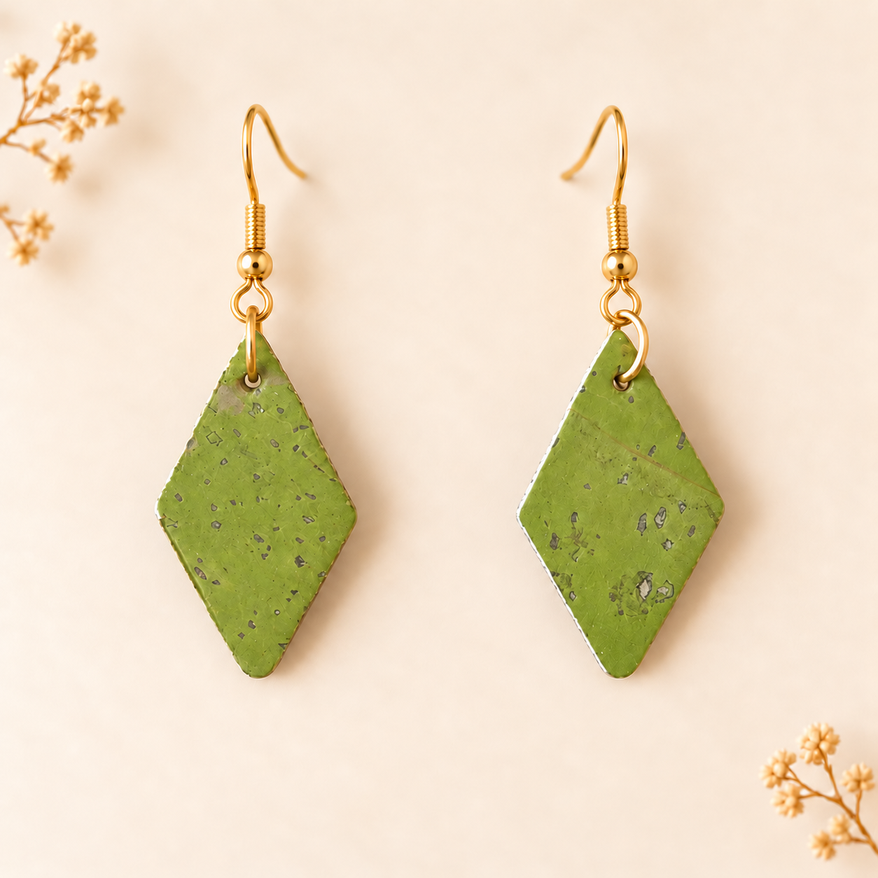 Earrings with diamond shaped green cork fabric and gold colored hooks.
