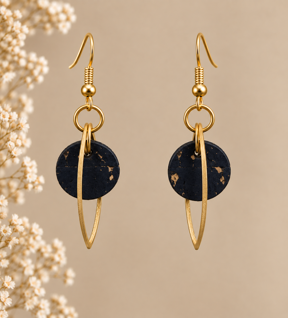 Round black cork fabric earrings with gold color marquise-shaped frames.