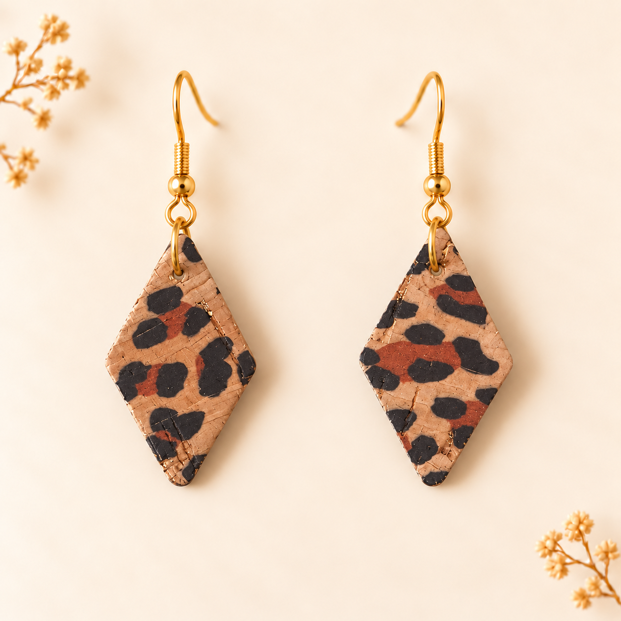 Earrings with diamond shaped cheetah pattern cork fabric and gold colored hooks.